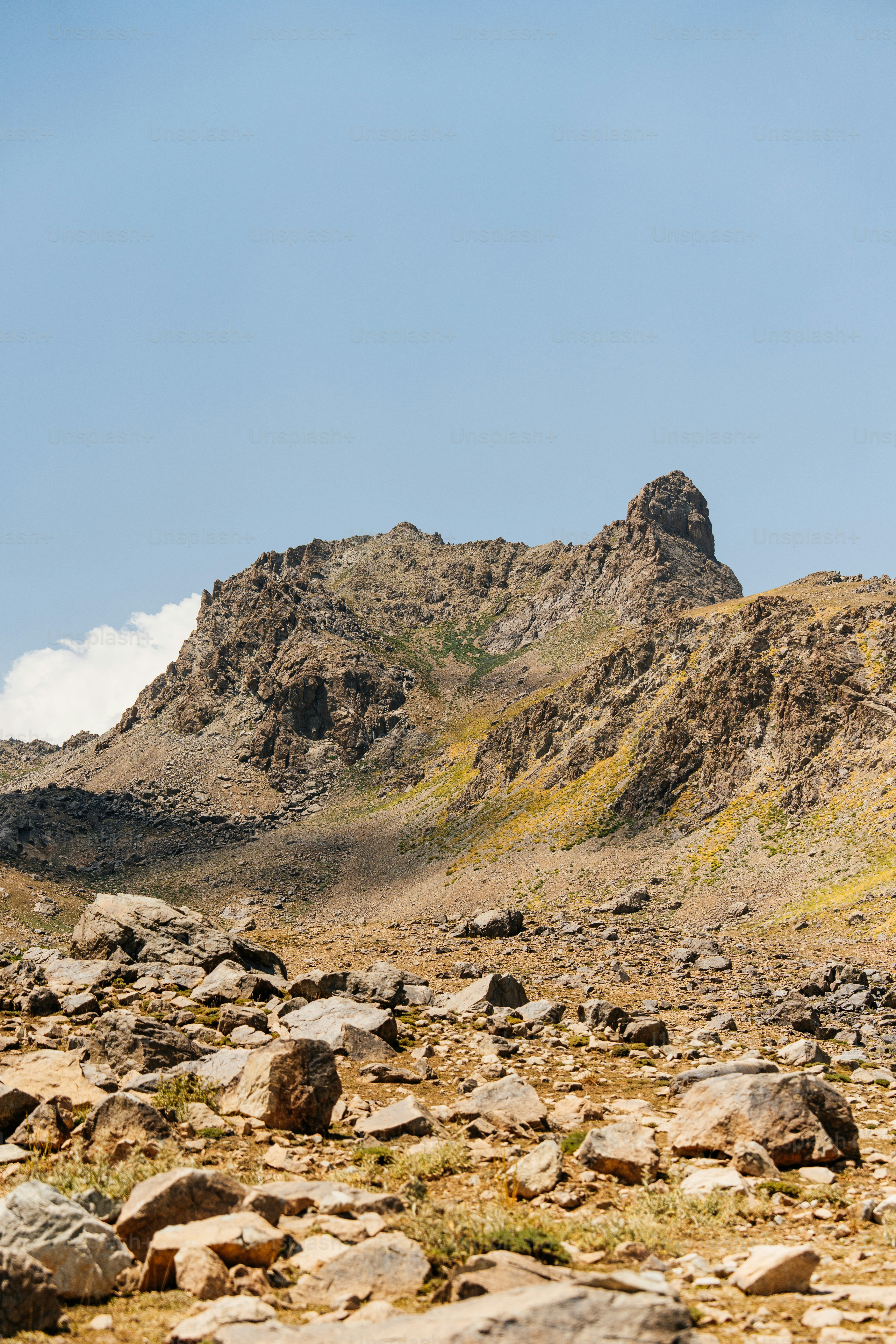 Rocky mountain terrain under a clear blue sky.