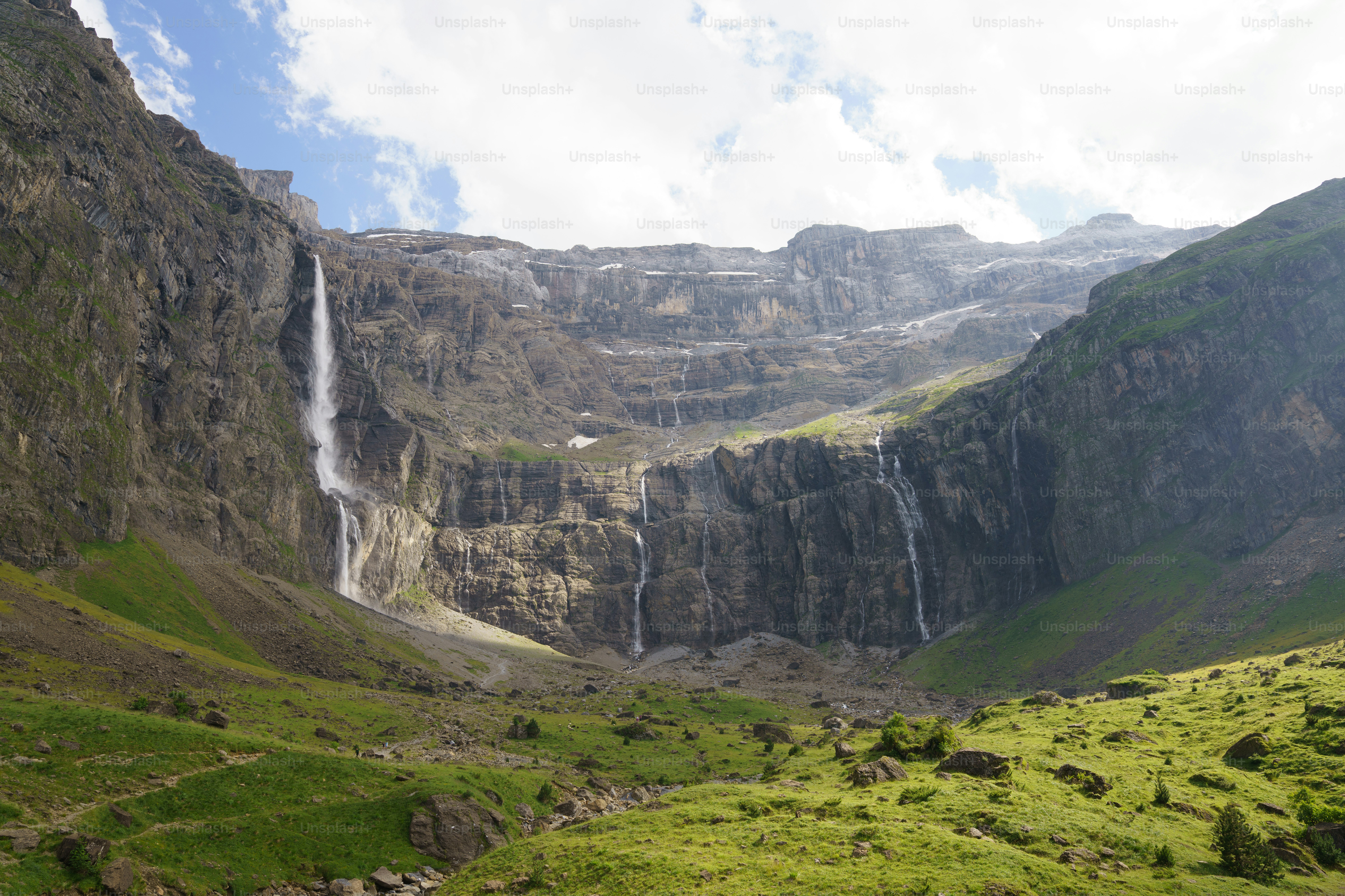 Majestuosas cascadas caen por una ladera rocosa de montaña.