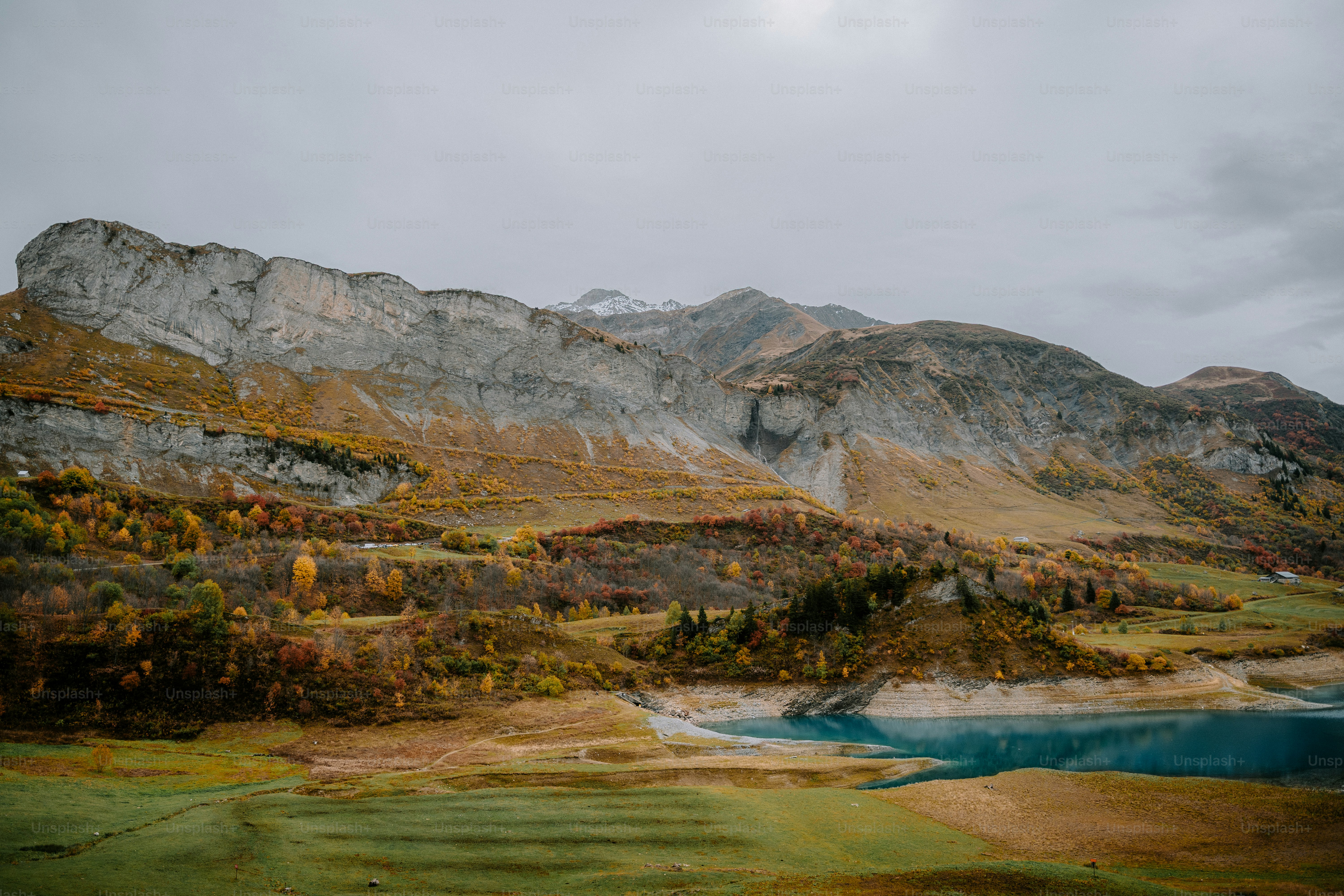 Paisaje montañoso con lago y árboles otoñales