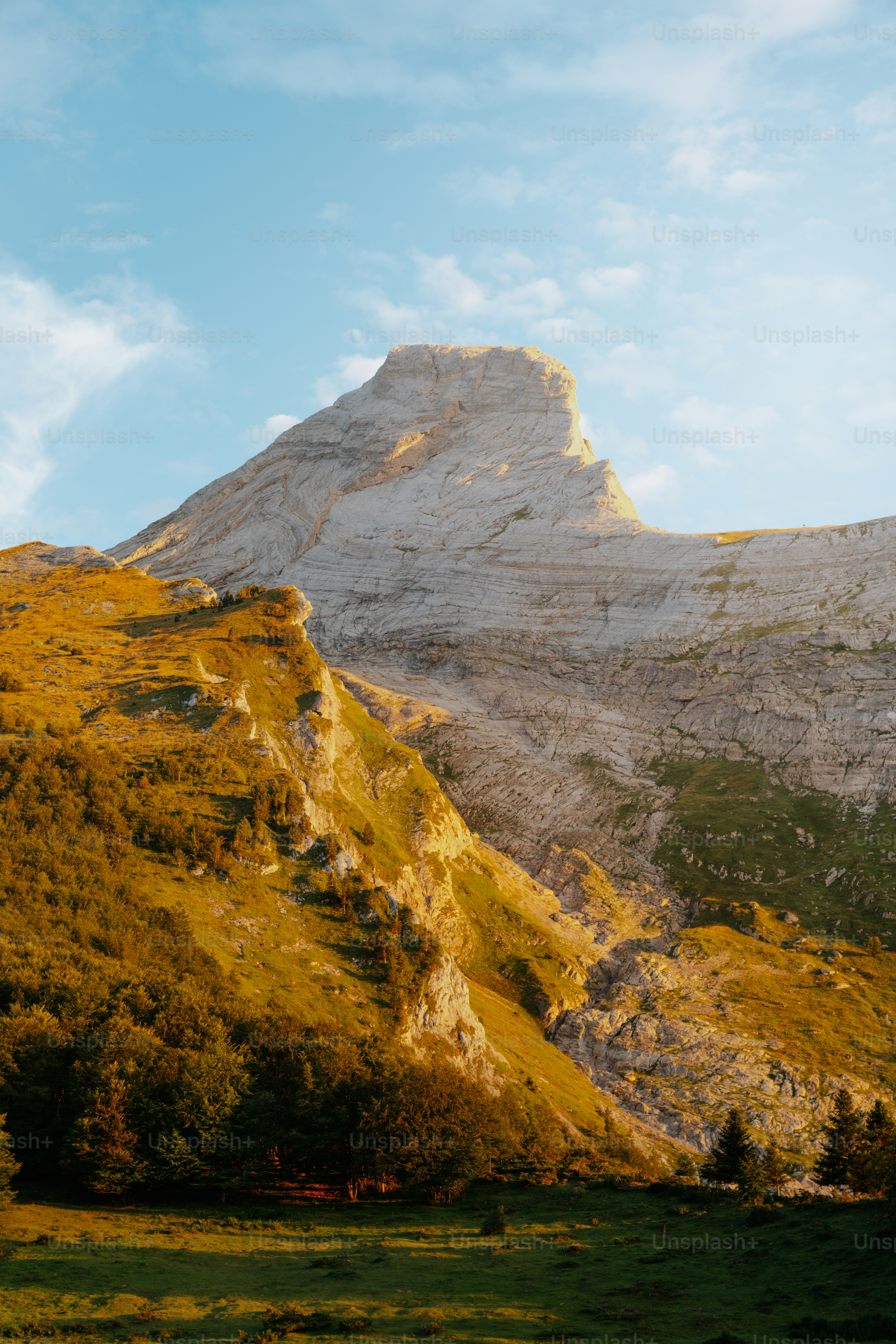 La luz dorada del sol ilumina un majestuoso paisaje montañoso.