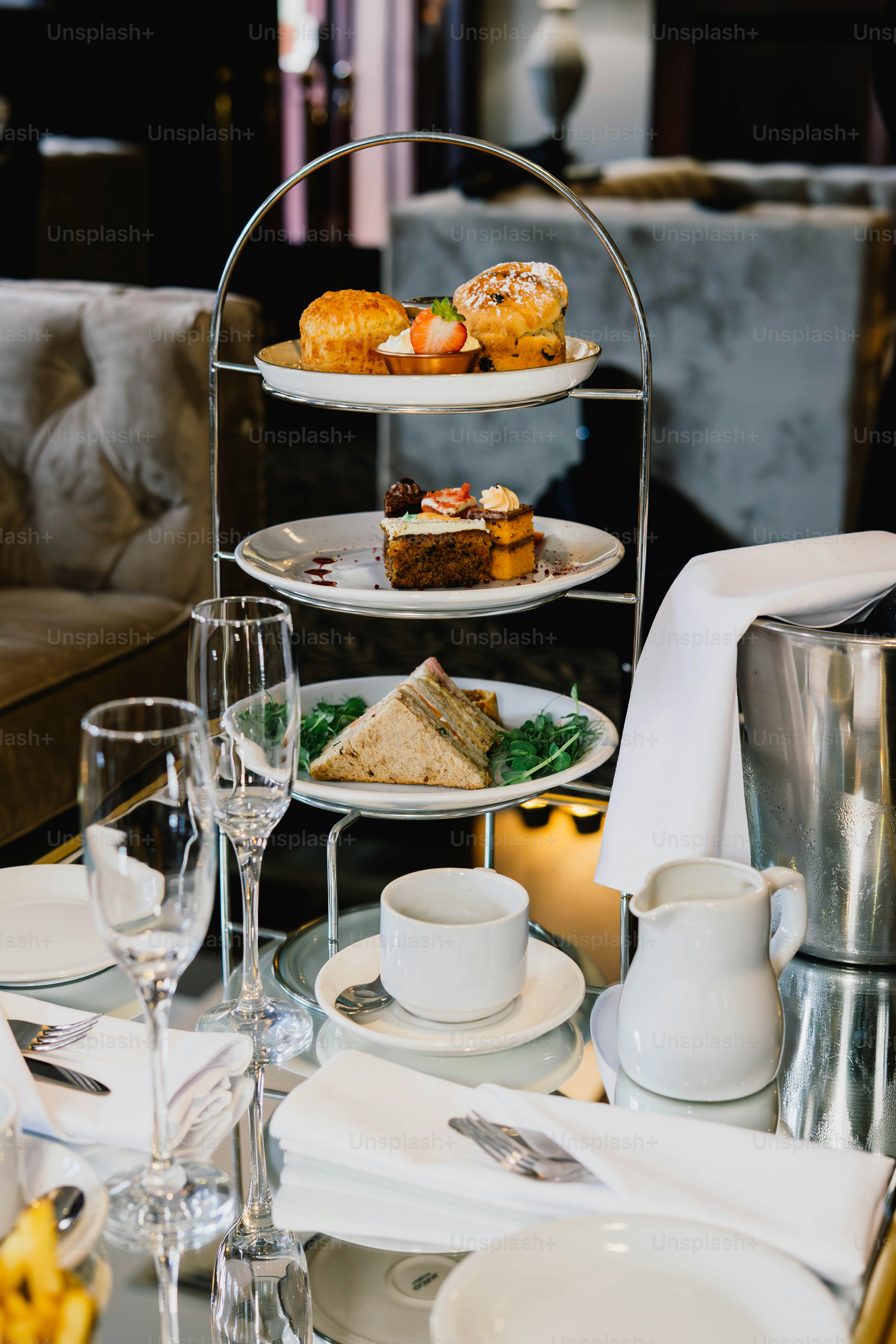 Tiered stand with pastries, sandwiches, and tea