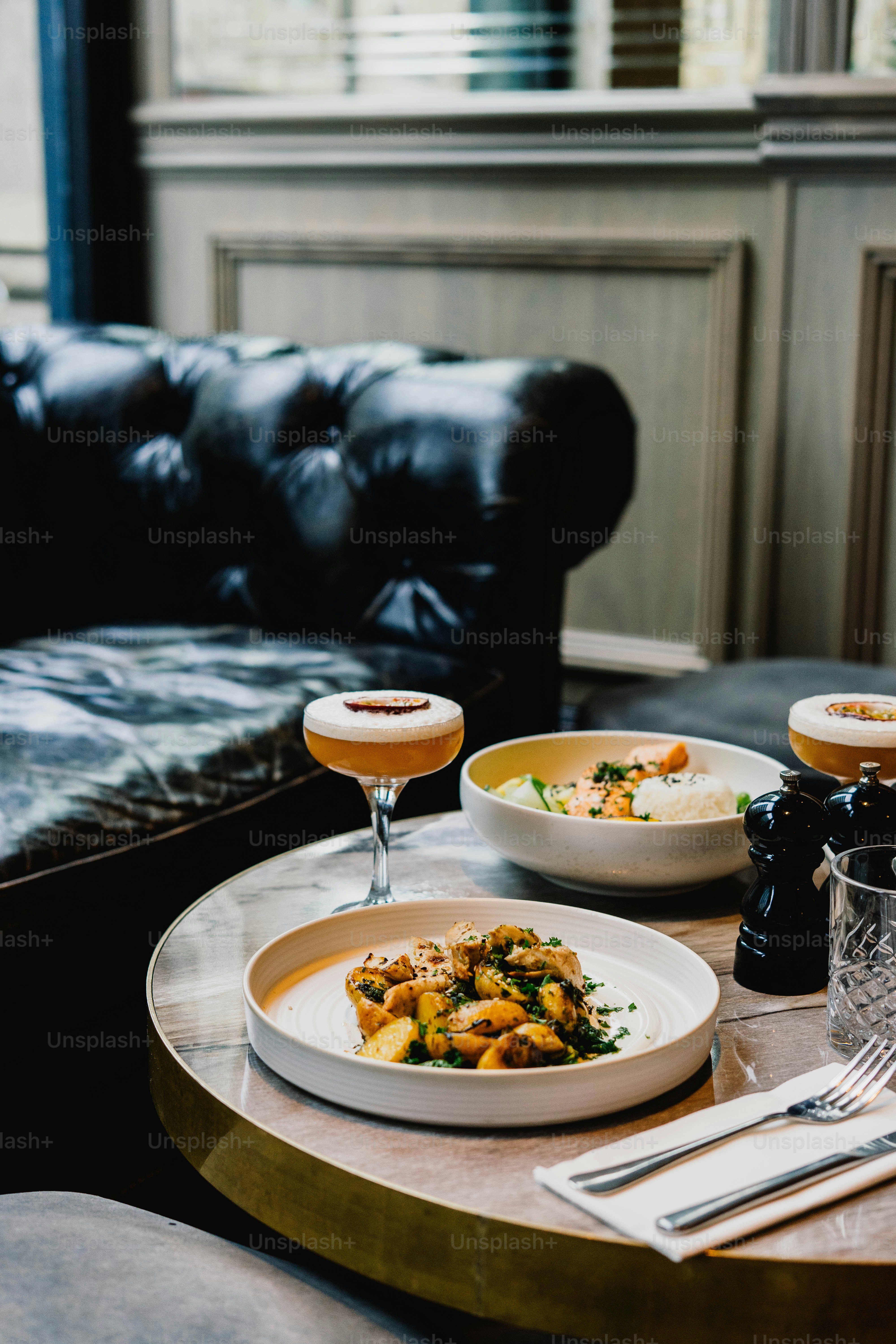 Deux assiettes de nourriture et un cocktail sur la table.