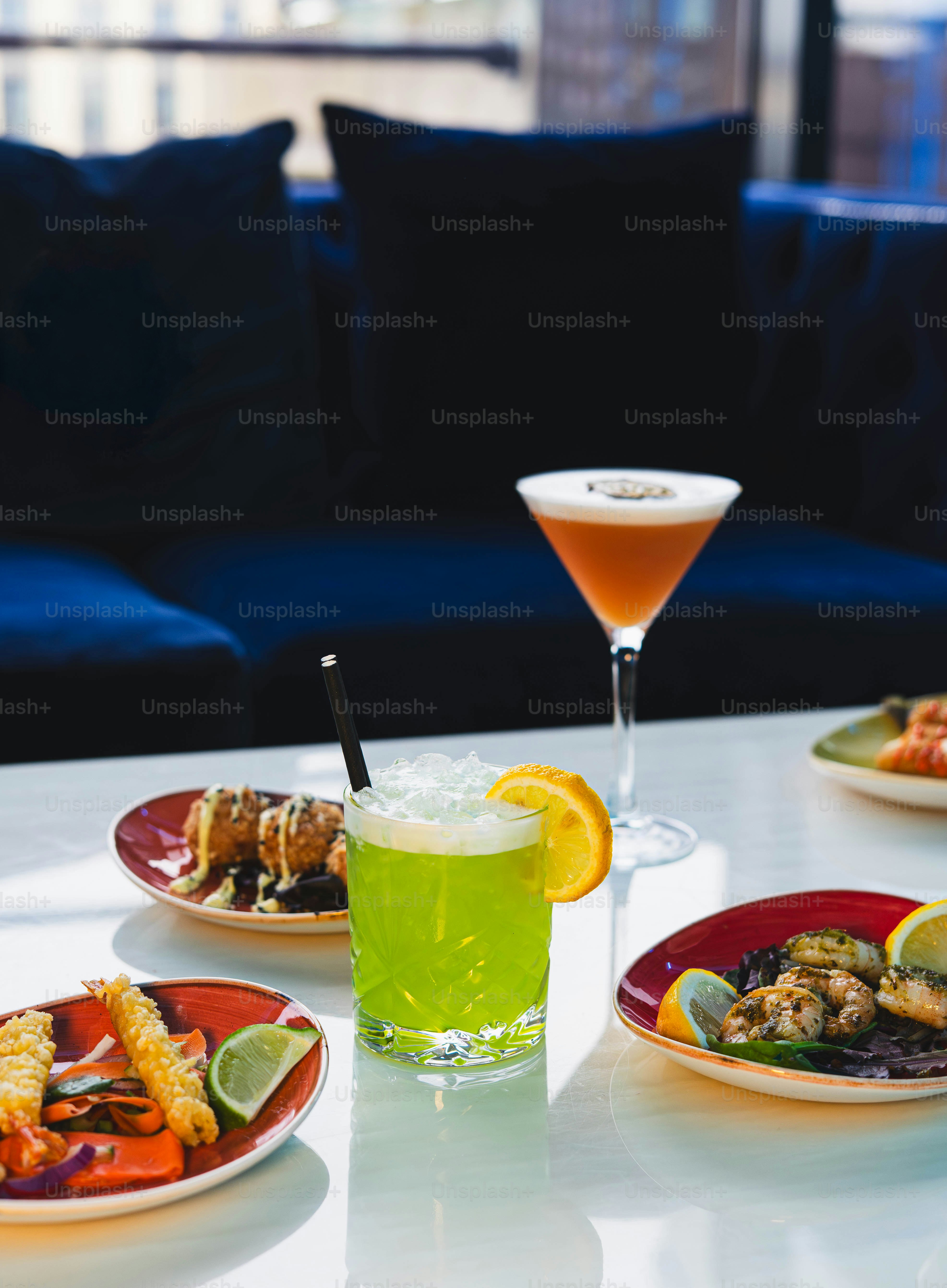 Cocktails and appetizers on a table with couch.