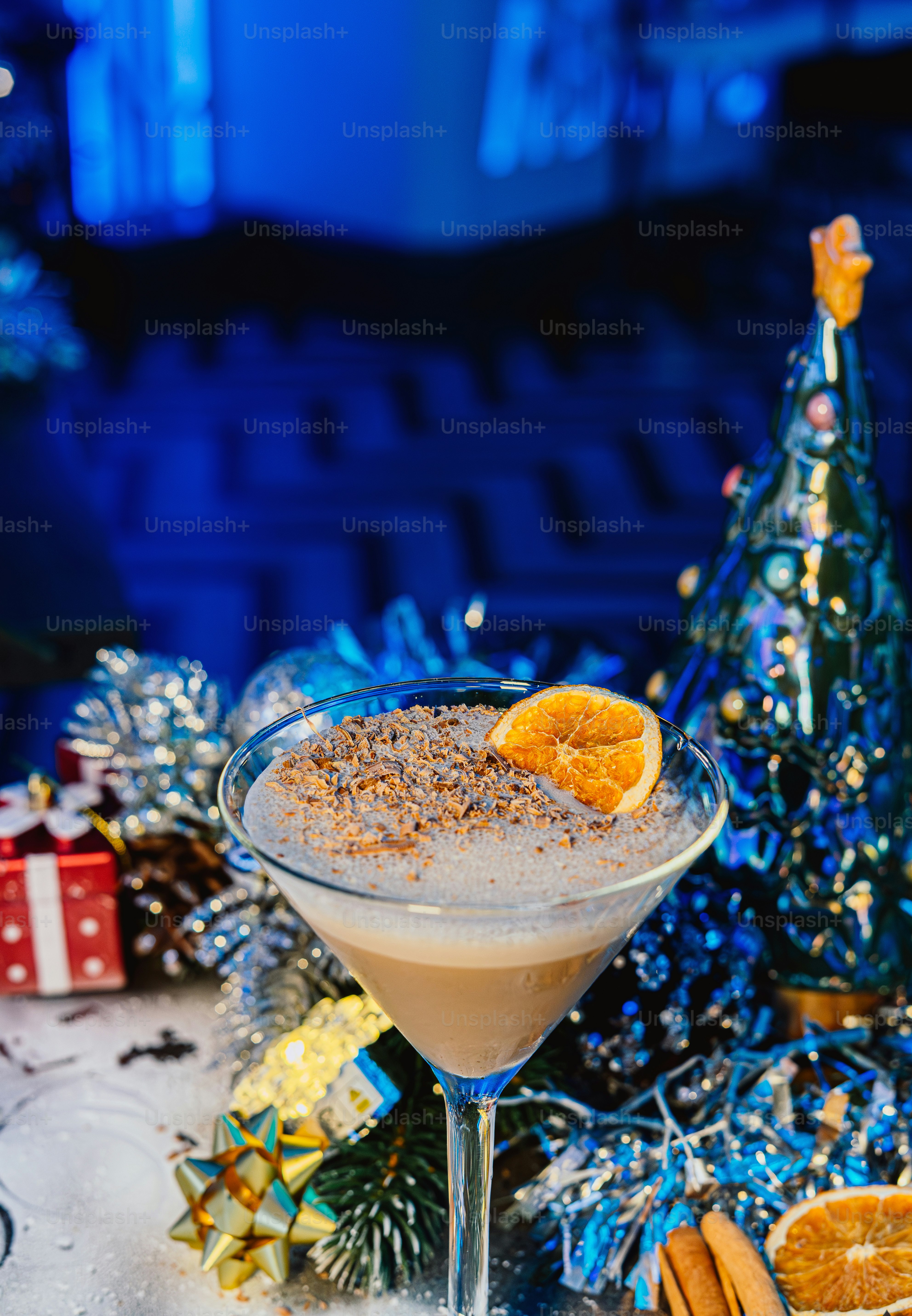 A festive cocktail garnished with orange and cinnamon.