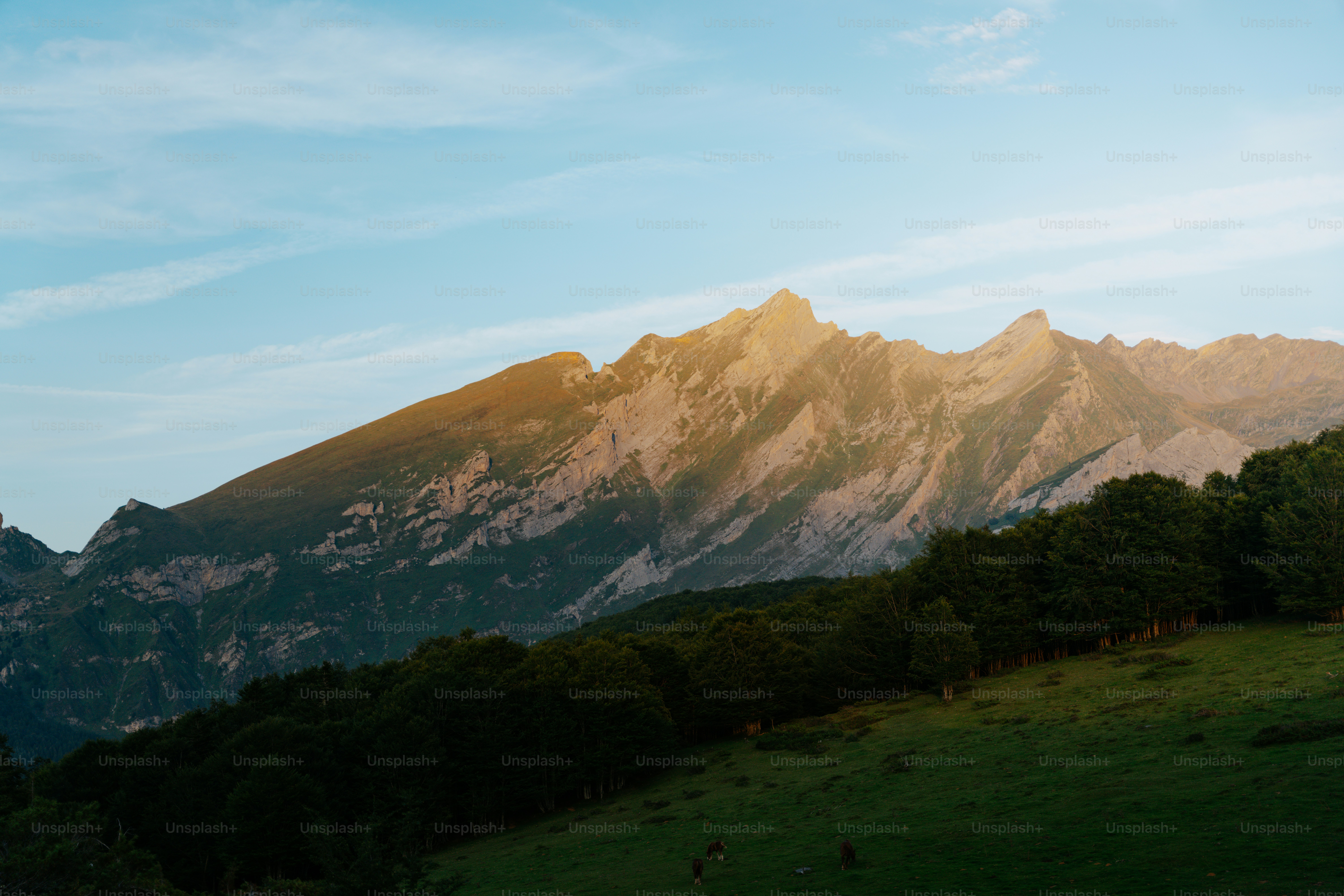 Sunlight hitting a majestic mountain range at dawn.