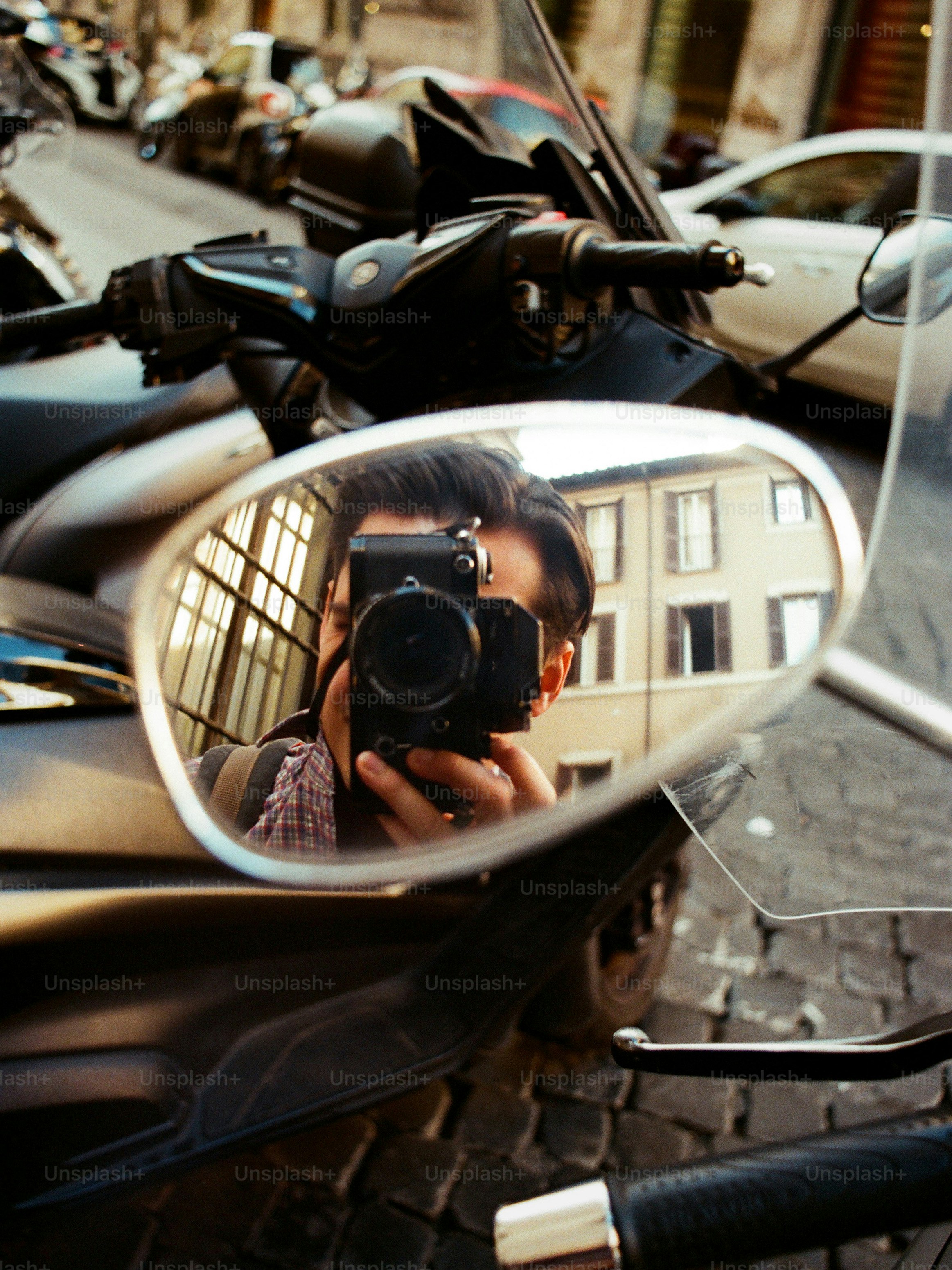 Man taking a selfie with a camera on a scooter.