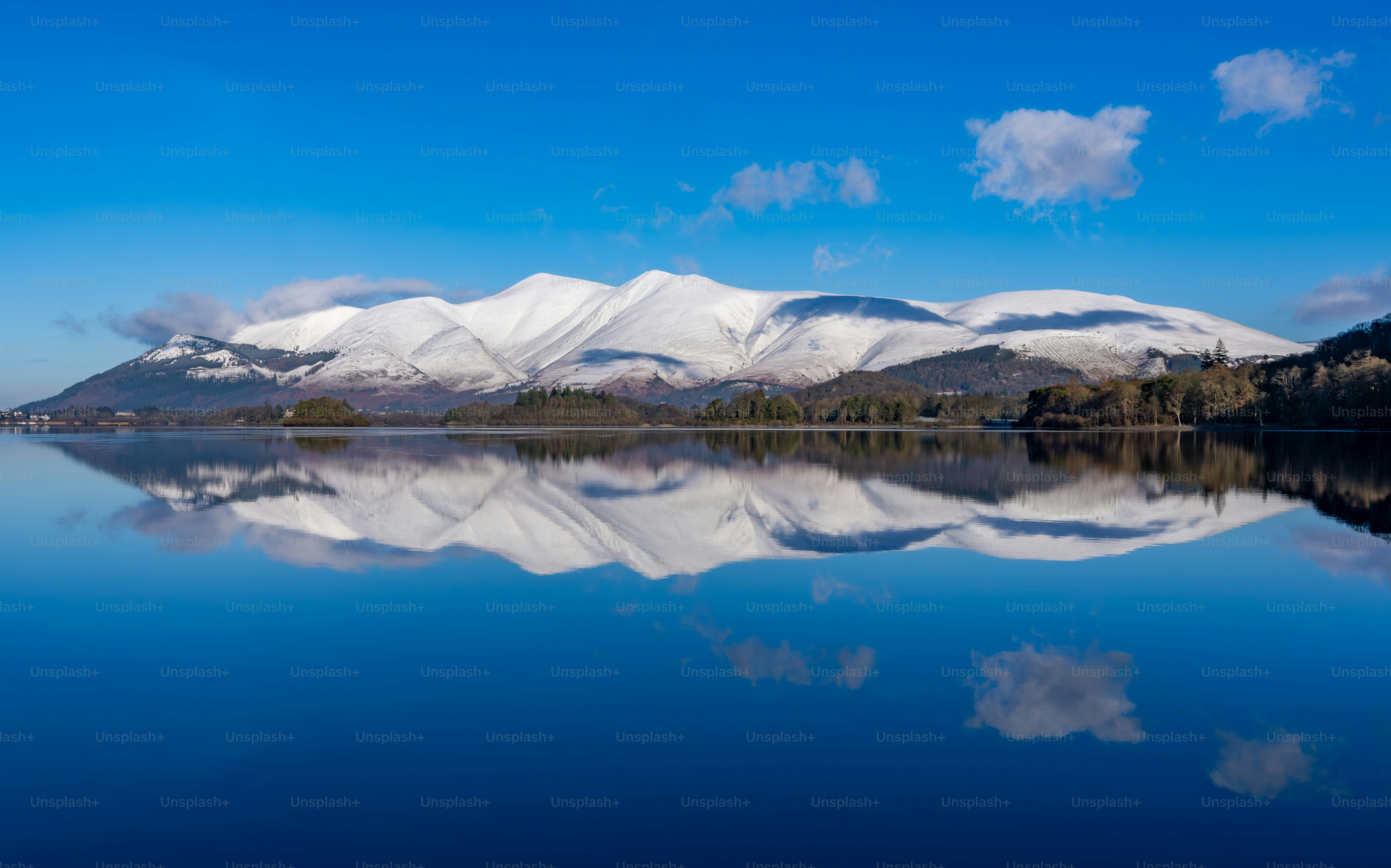 Schneebedeckte Berge spiegeln sich in einem ruhigen See wider