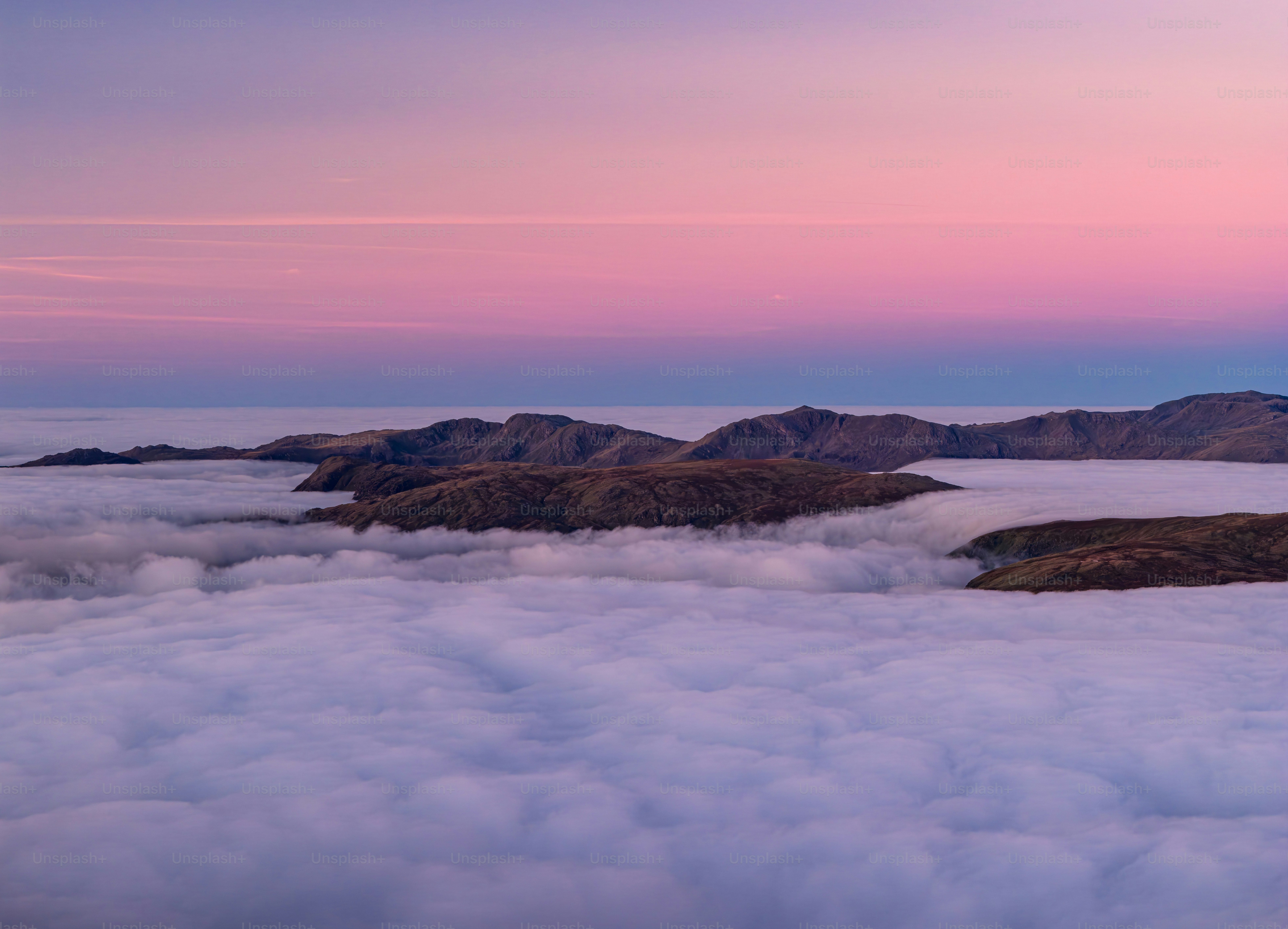 Mountains emerge from a sea of clouds at dawn.