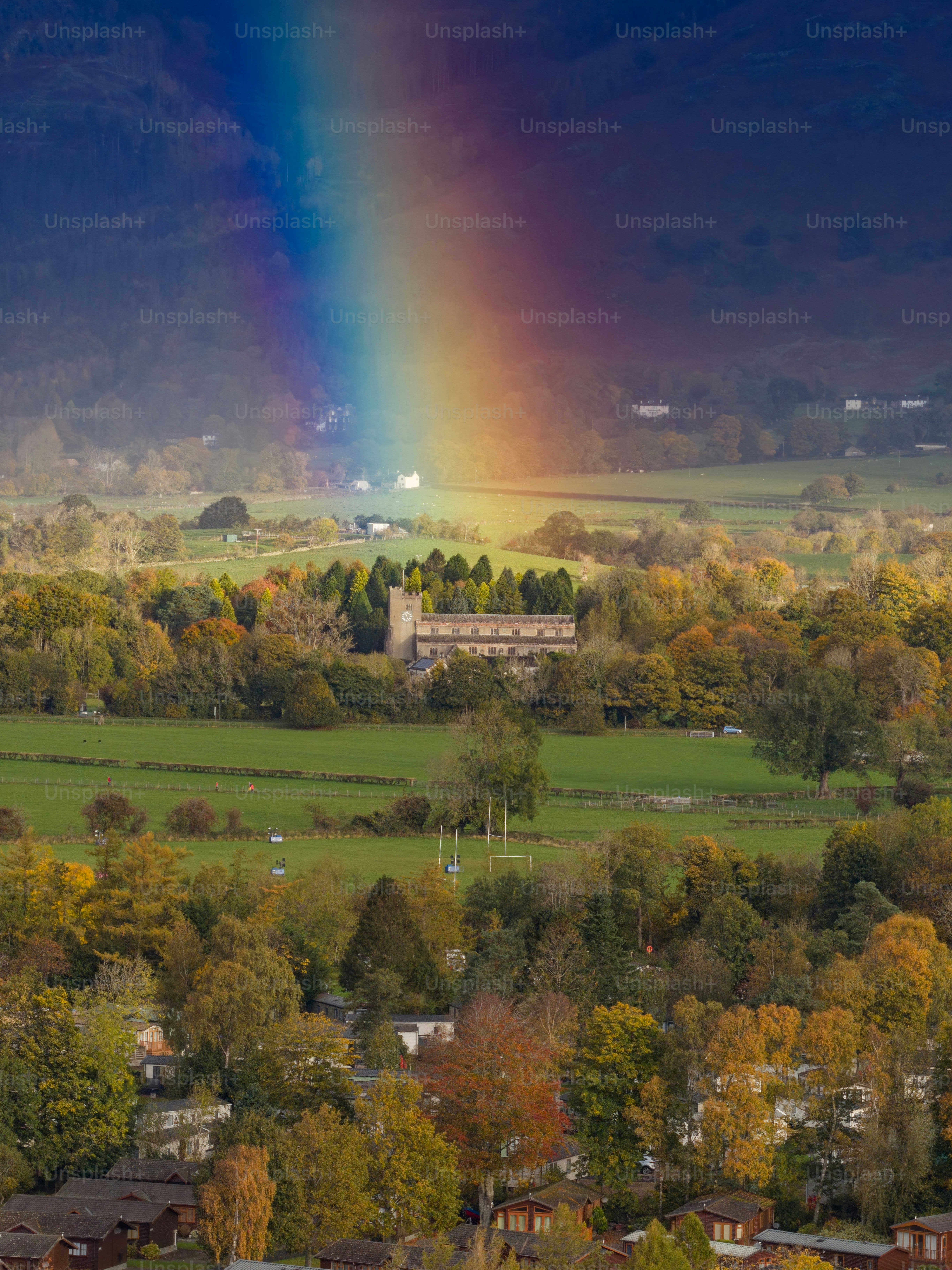 Regenbogen über einer Kirche und Herbstbäumen