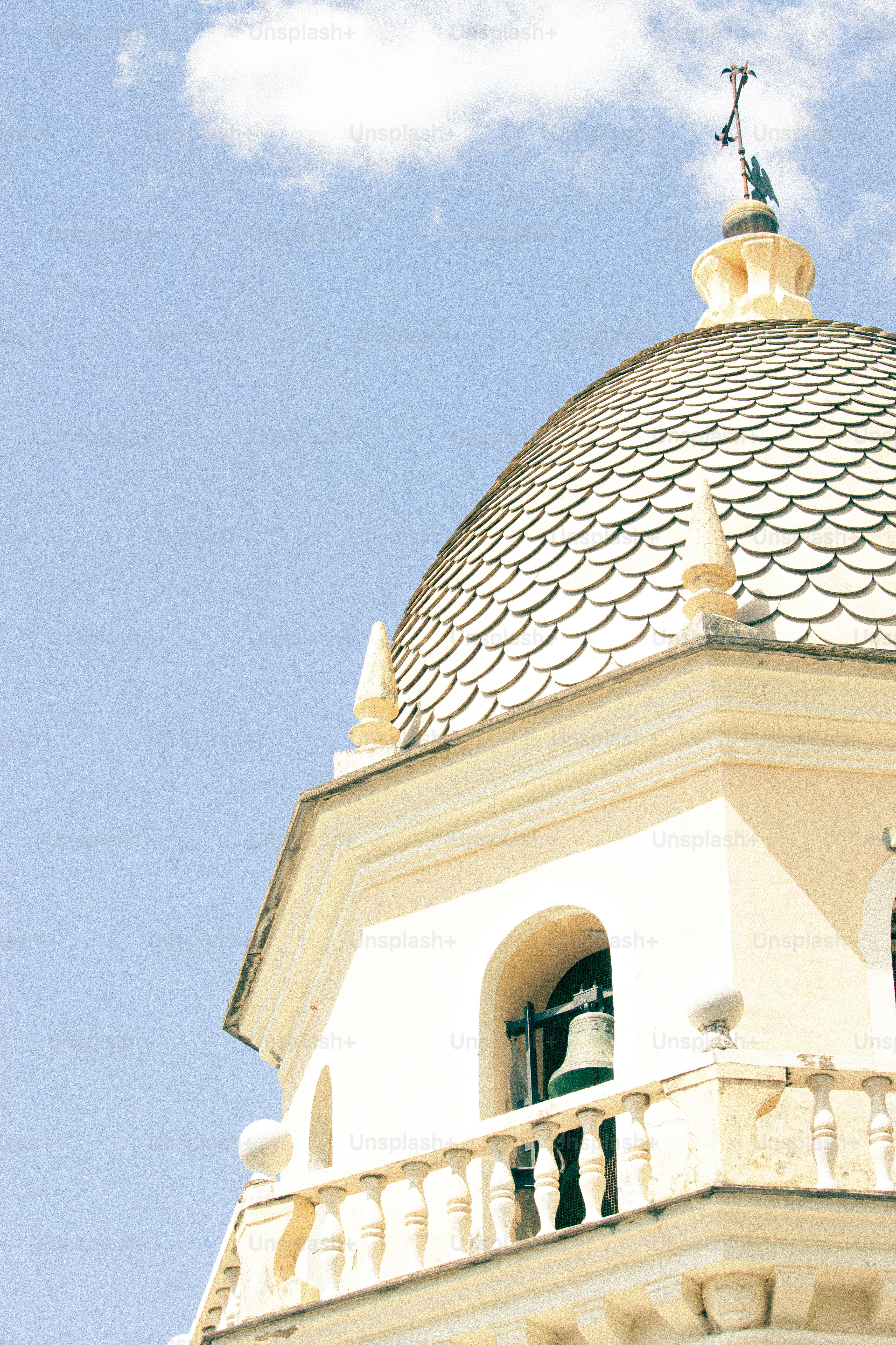Glockenturm mit einer Kuppel vor blauem Himmel.
