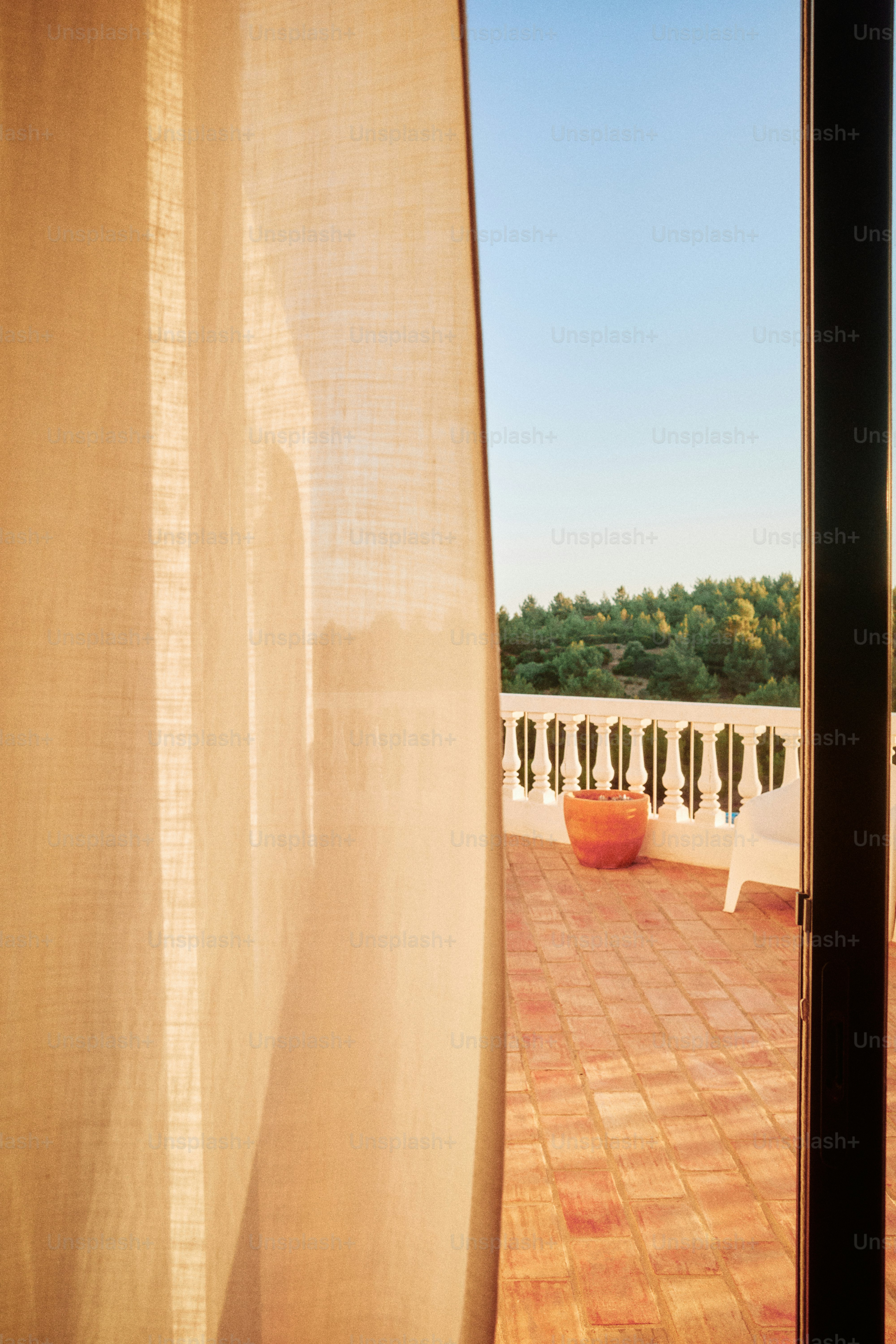 Terrassenblick mit Vorhang und Topfpflanze.