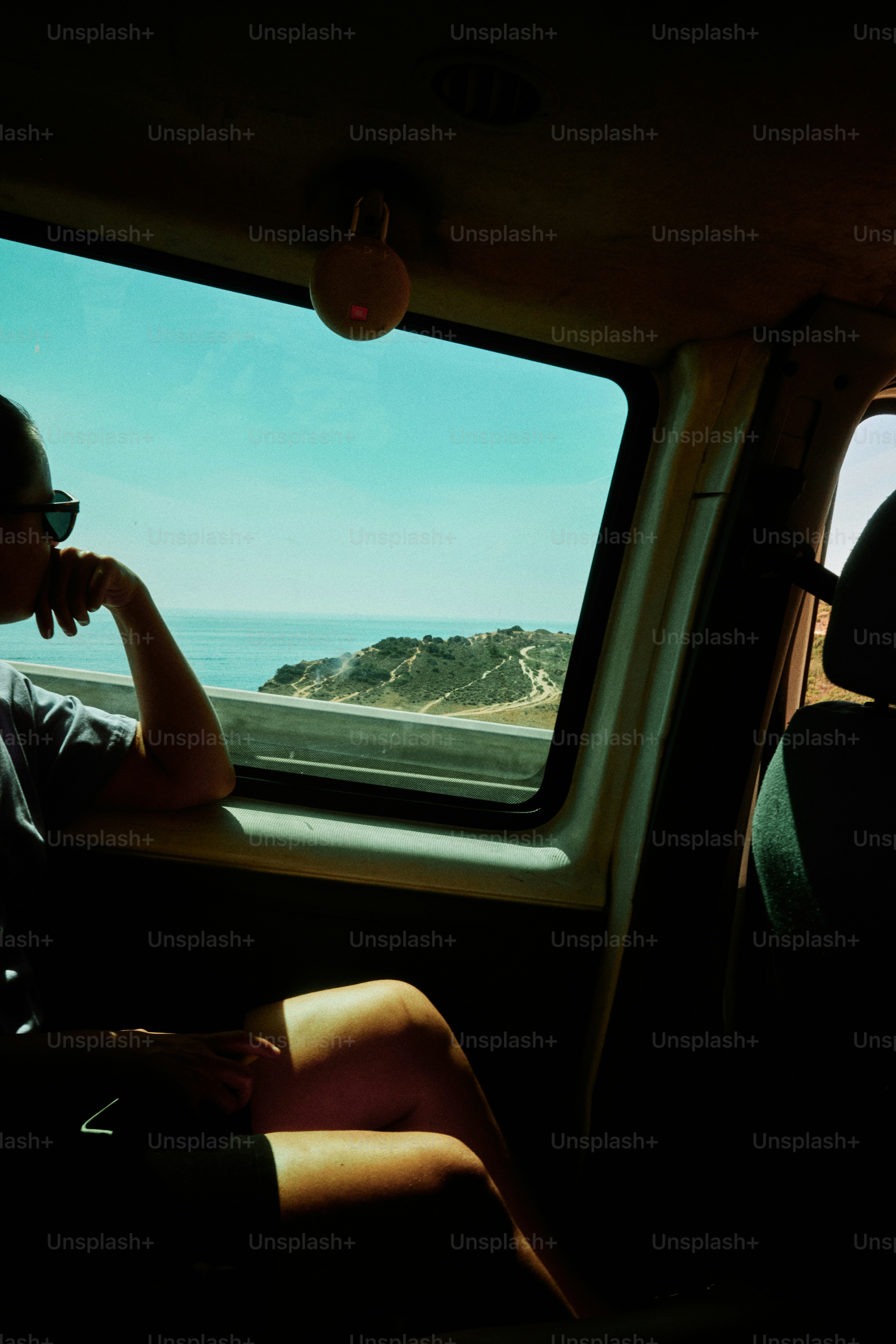 Mujer mirando por la ventana del coche el paisaje costero