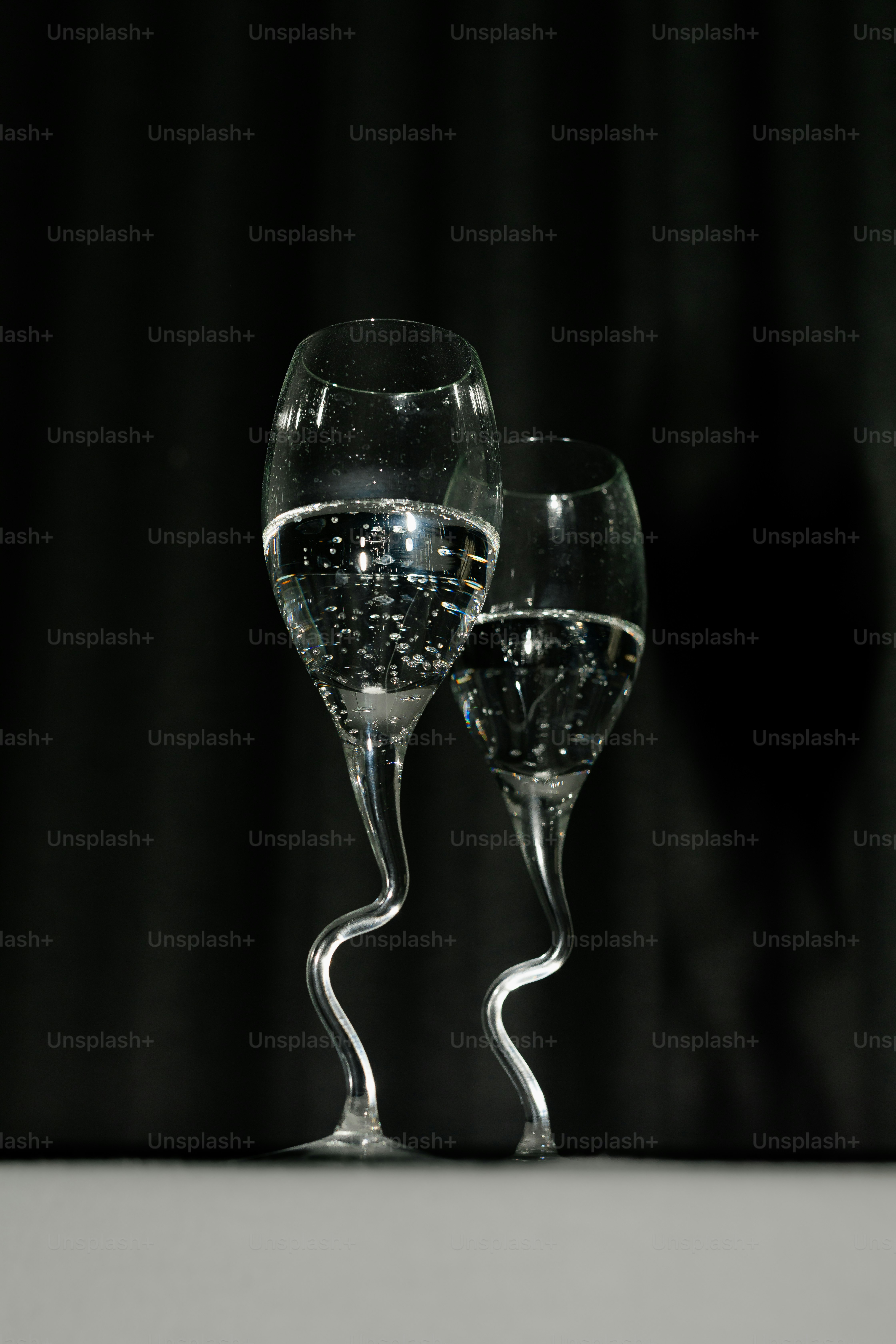 Two glasses of sparkling water on black background