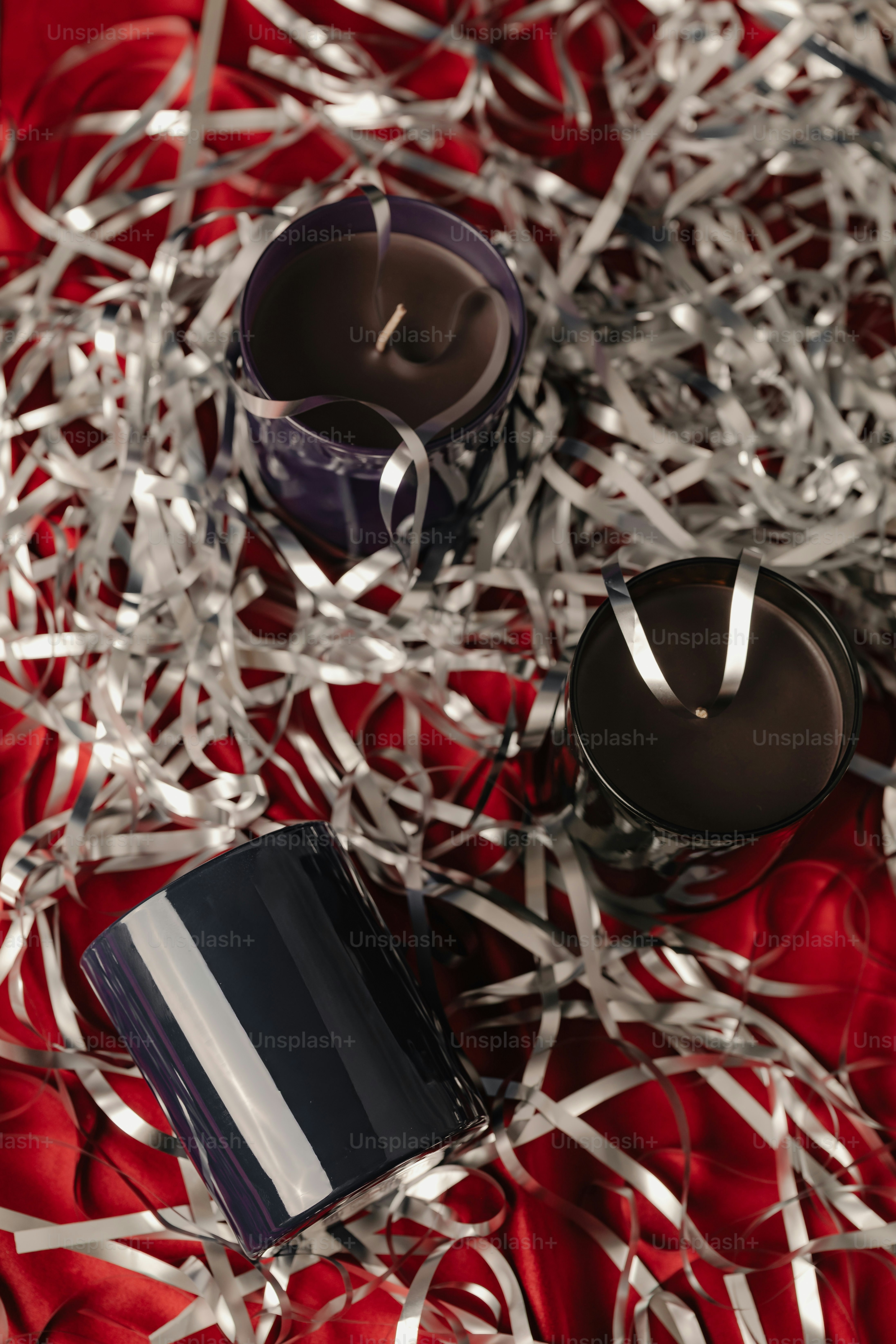 Tres velas anidadas entre espumillón de plata