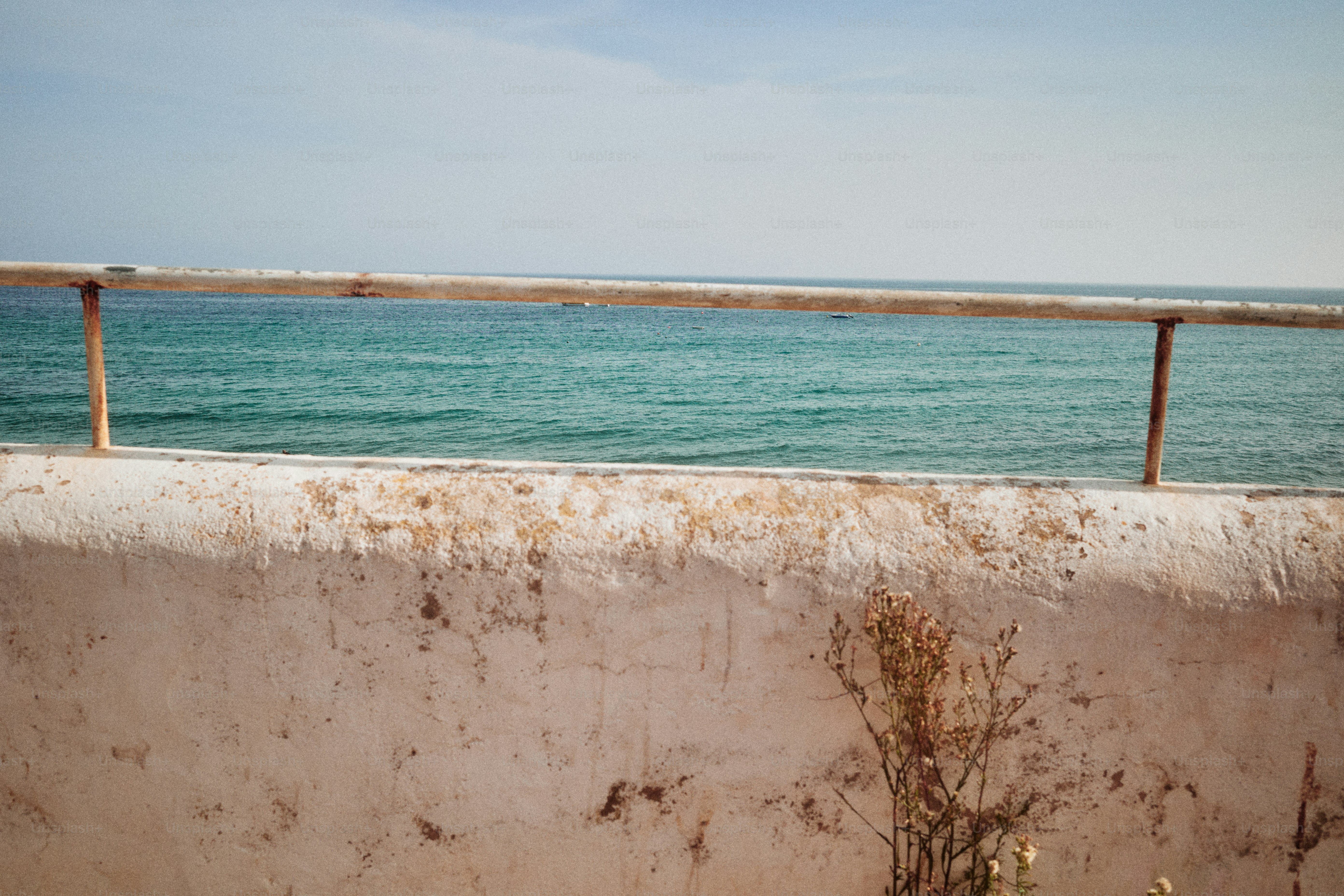 Agua turquesa del océano vista sobre una pared desgastada.