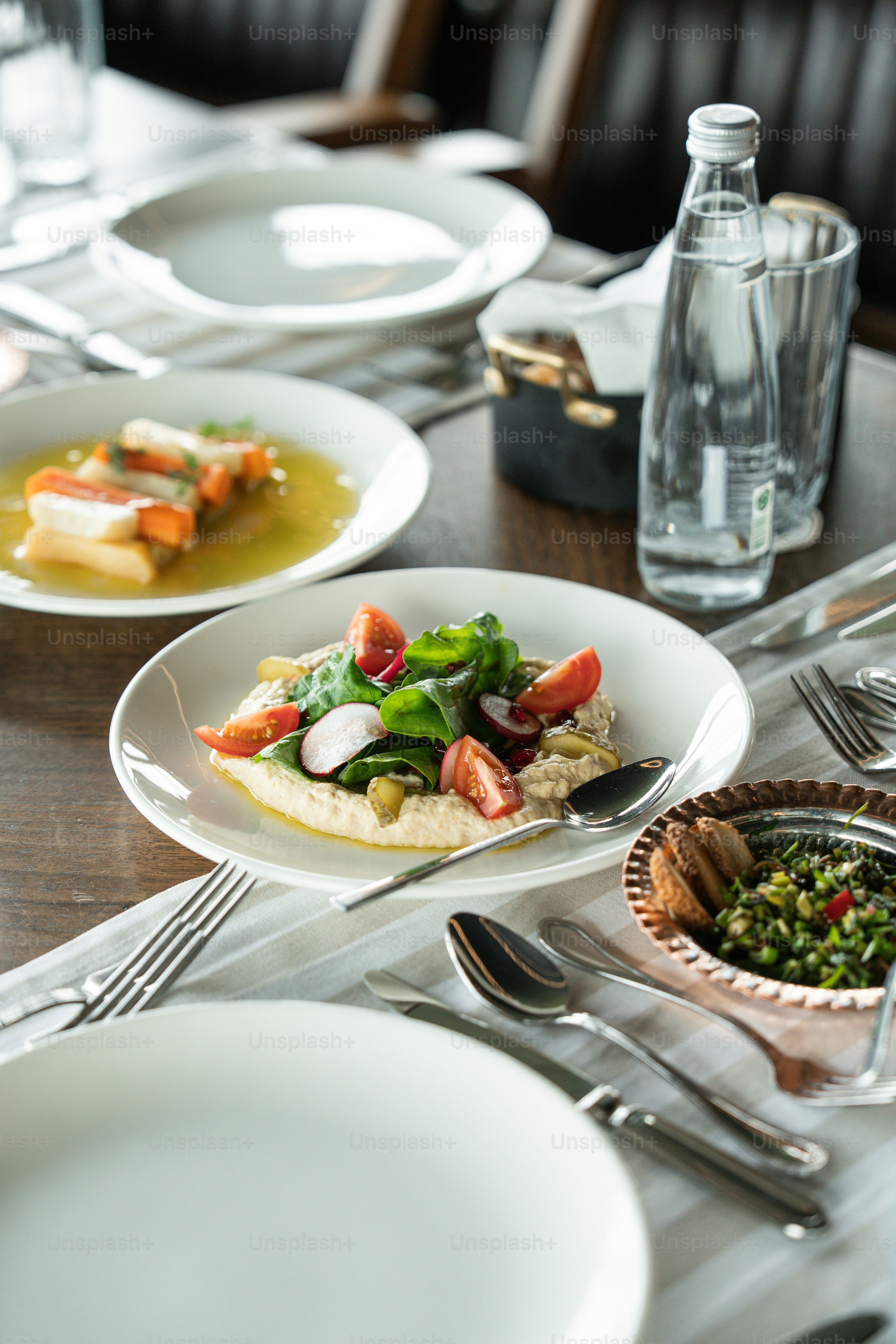 Hummus con pomodori e verdure su un tavolo.