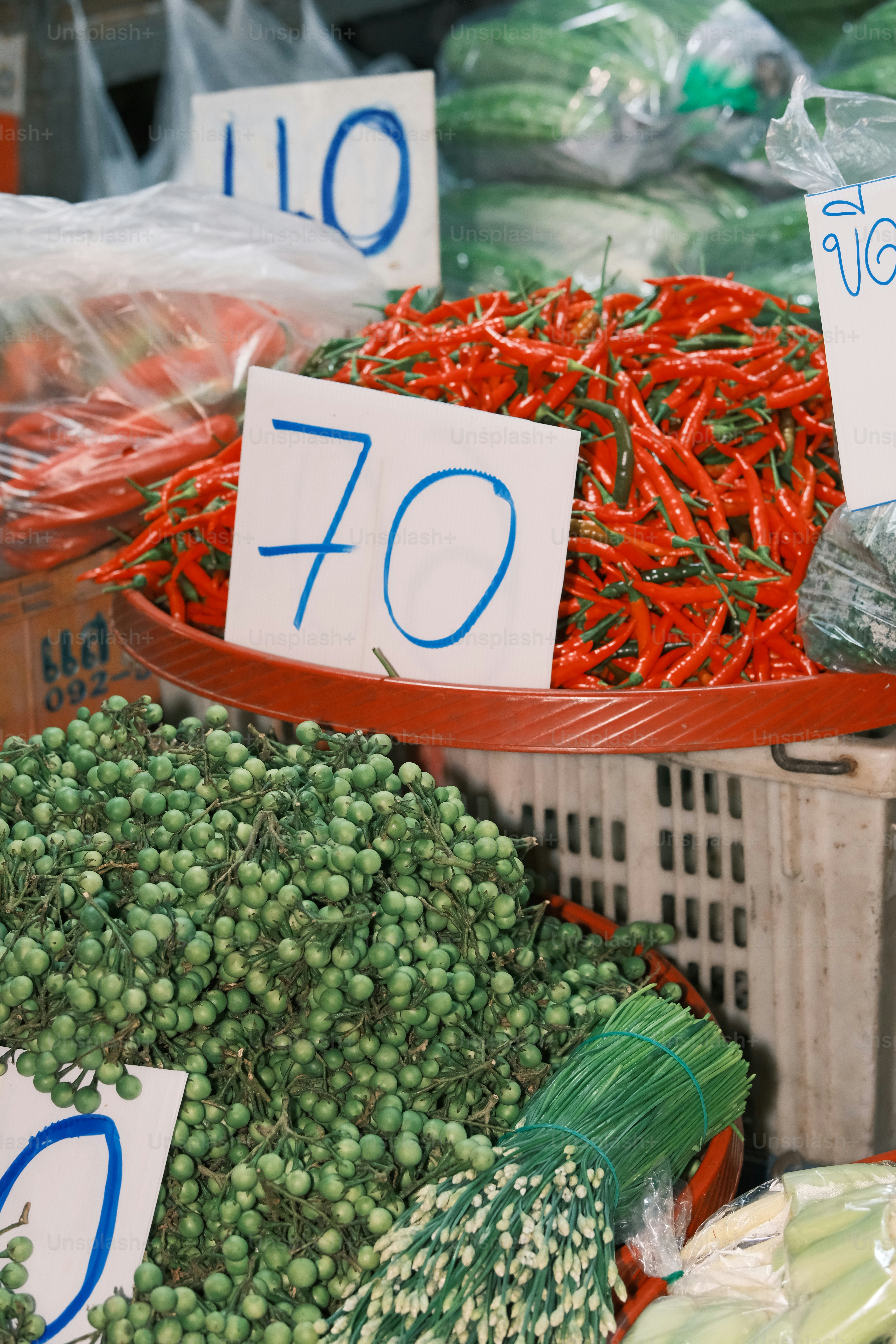 Fresh red chilies and green berries at market