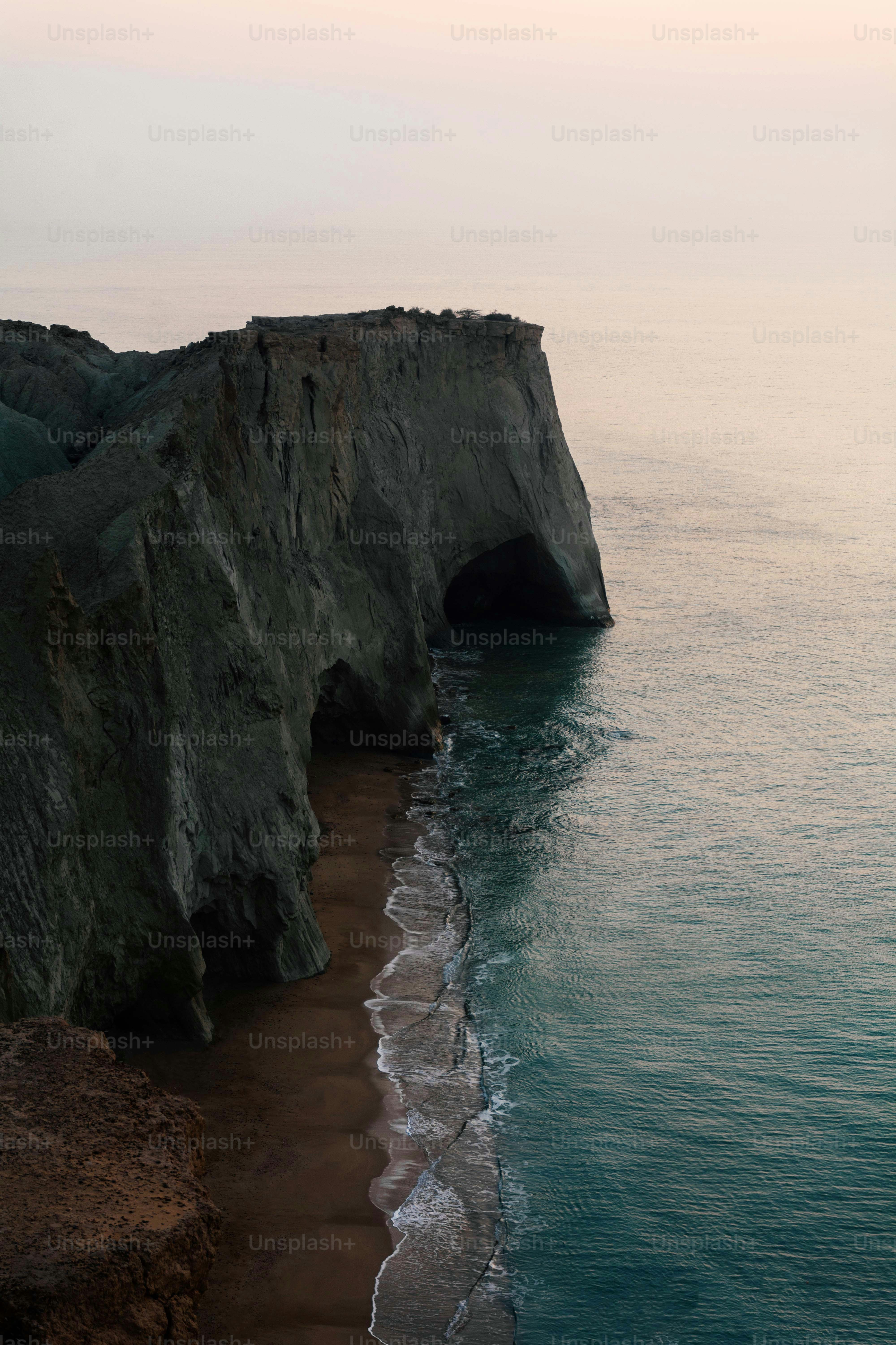 Coastal cliffs with ocean waves and sandy beach.