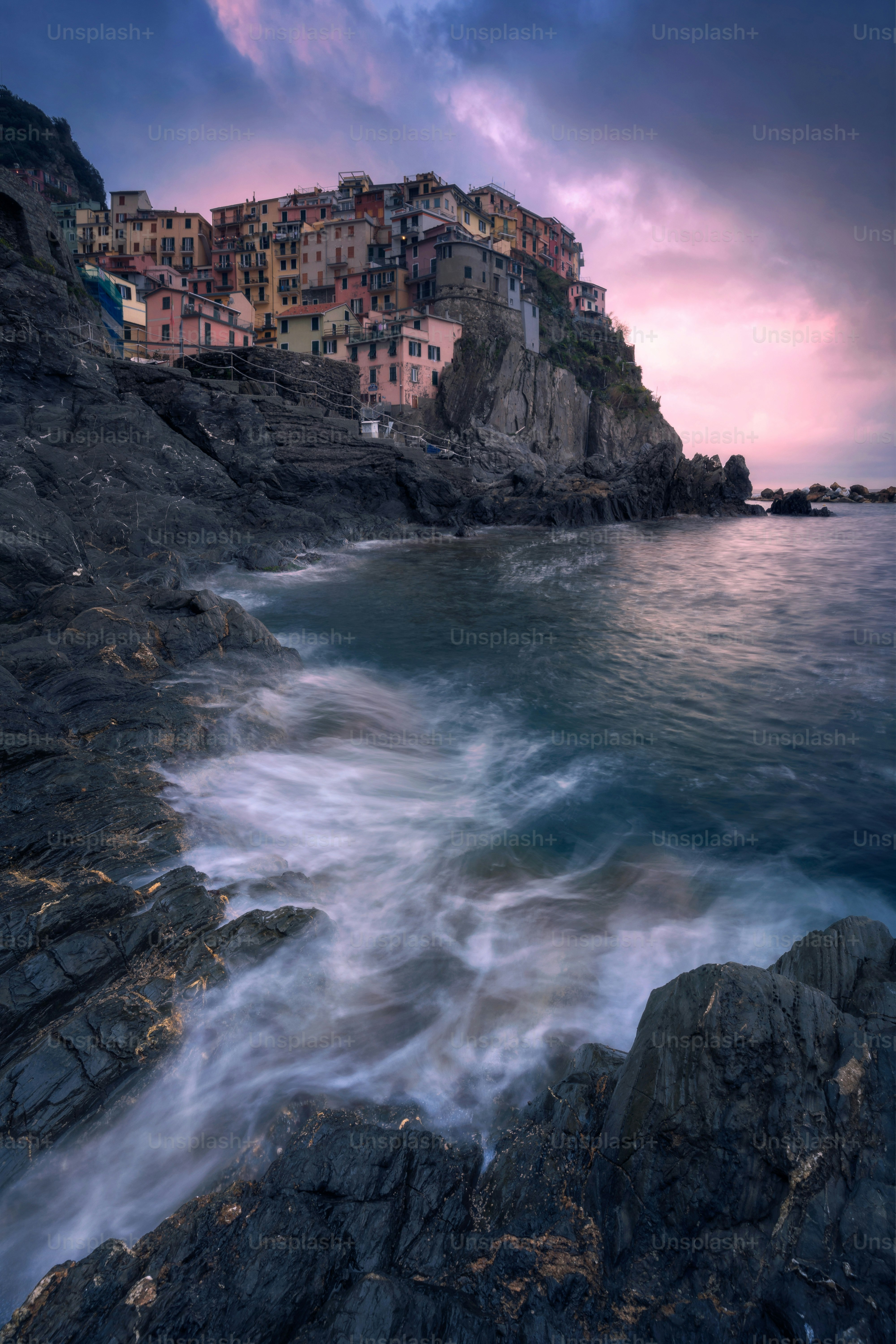 Colorful village on rocky coast at sunset