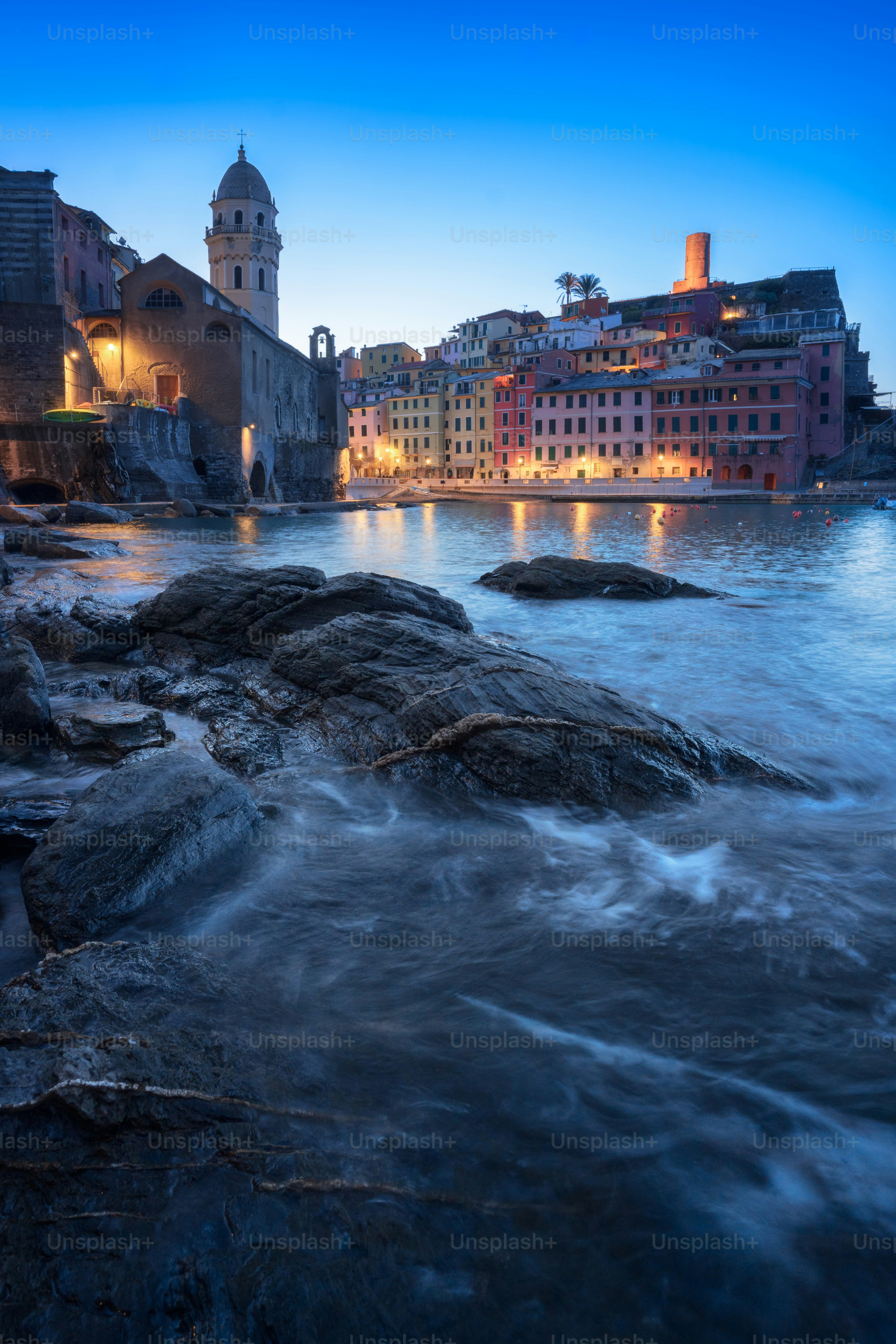 Colorful buildings line a harbor at twilight.