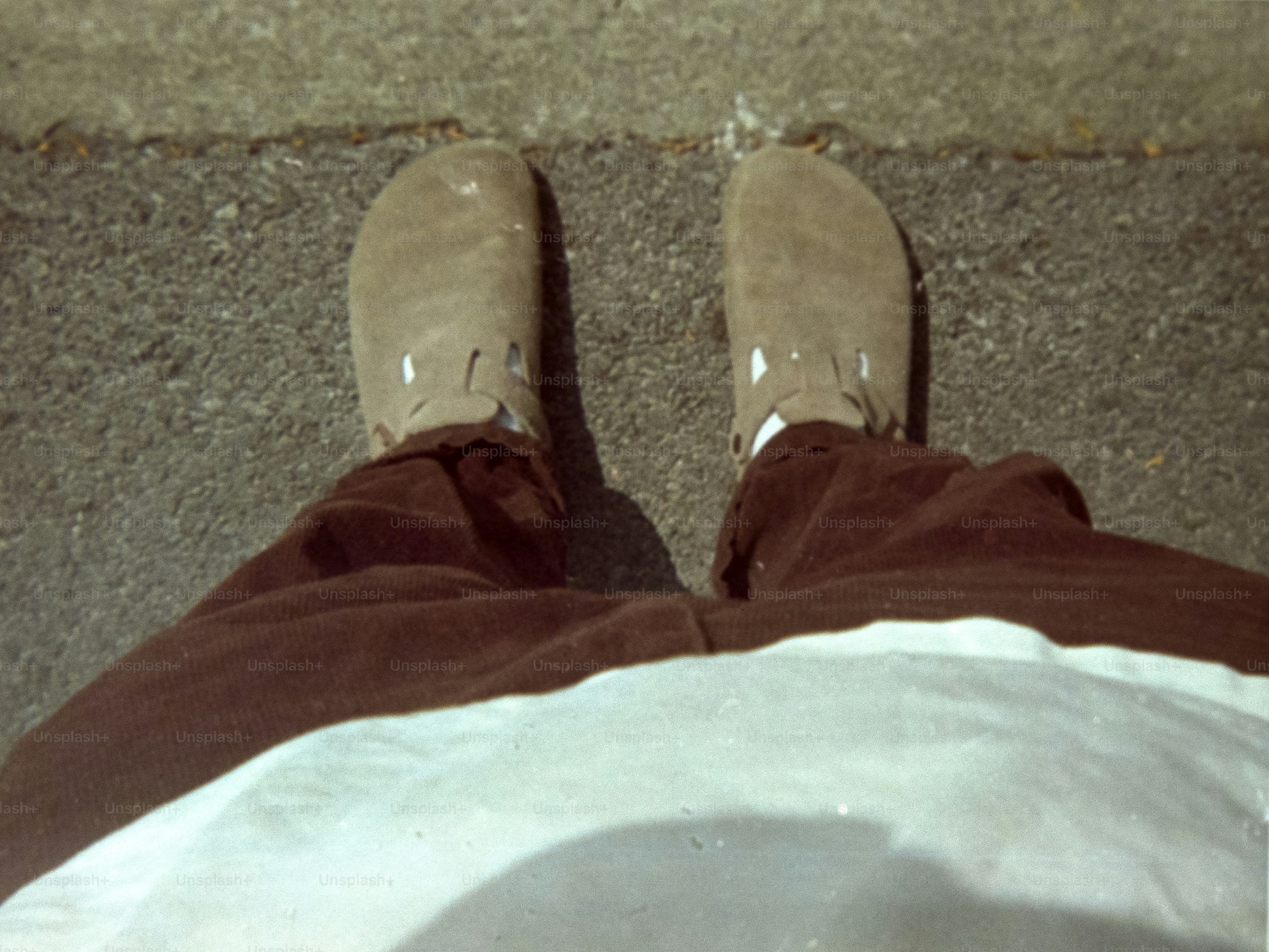 A person wearing brown pants and moccasins