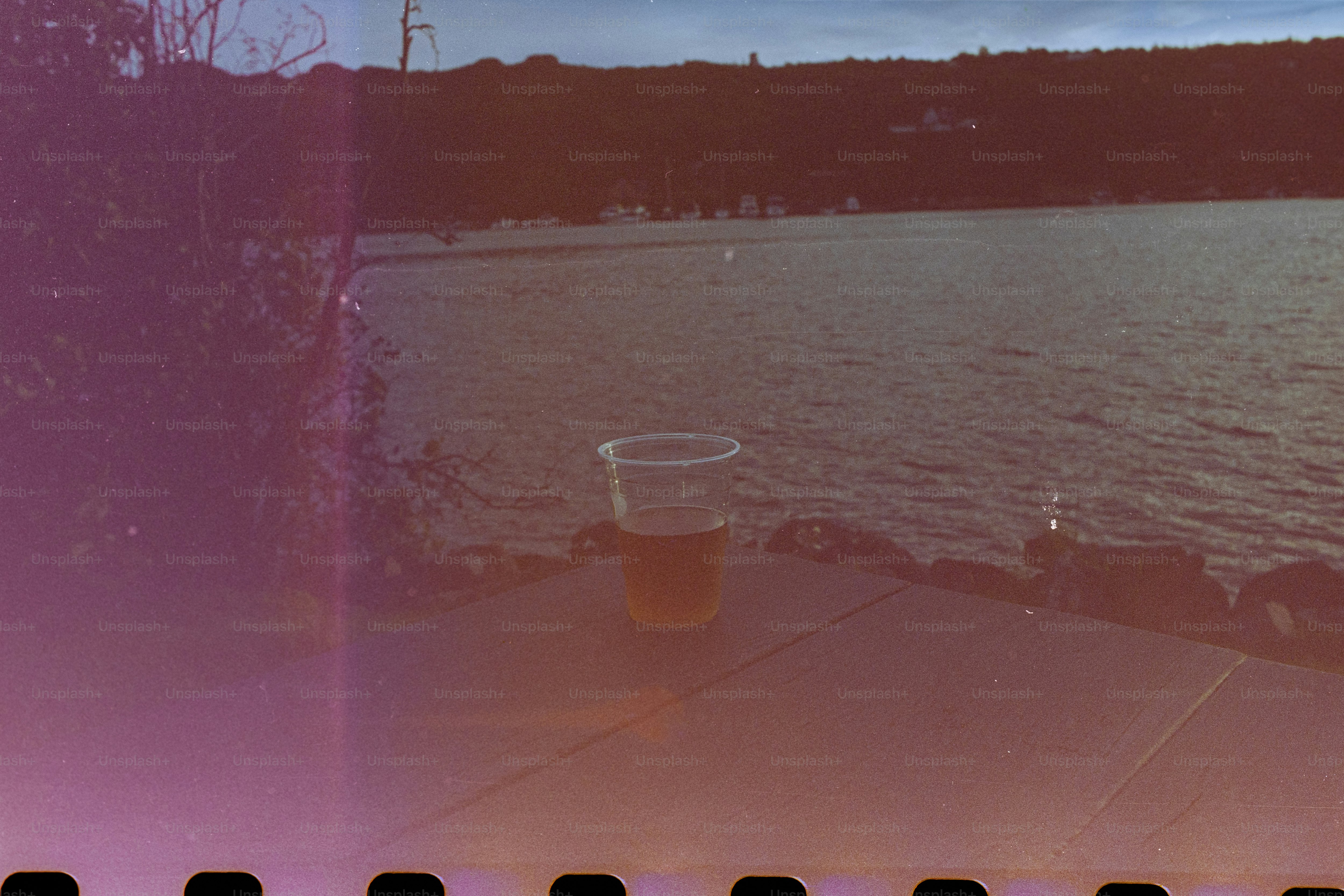 Uma bebida em uma mesa perto da água