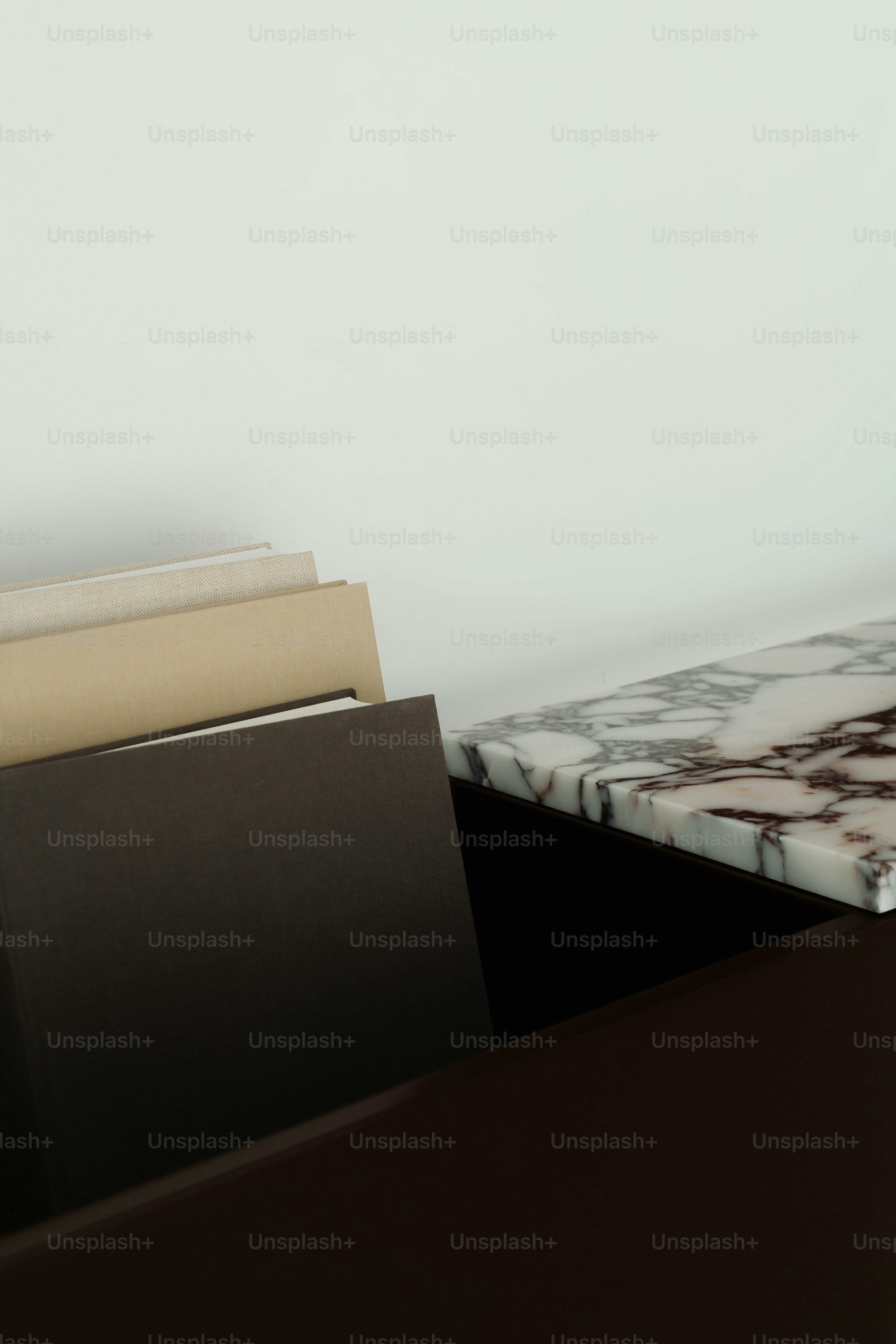 Stapel Bücher auf einer Marmorarbeitsplatte.