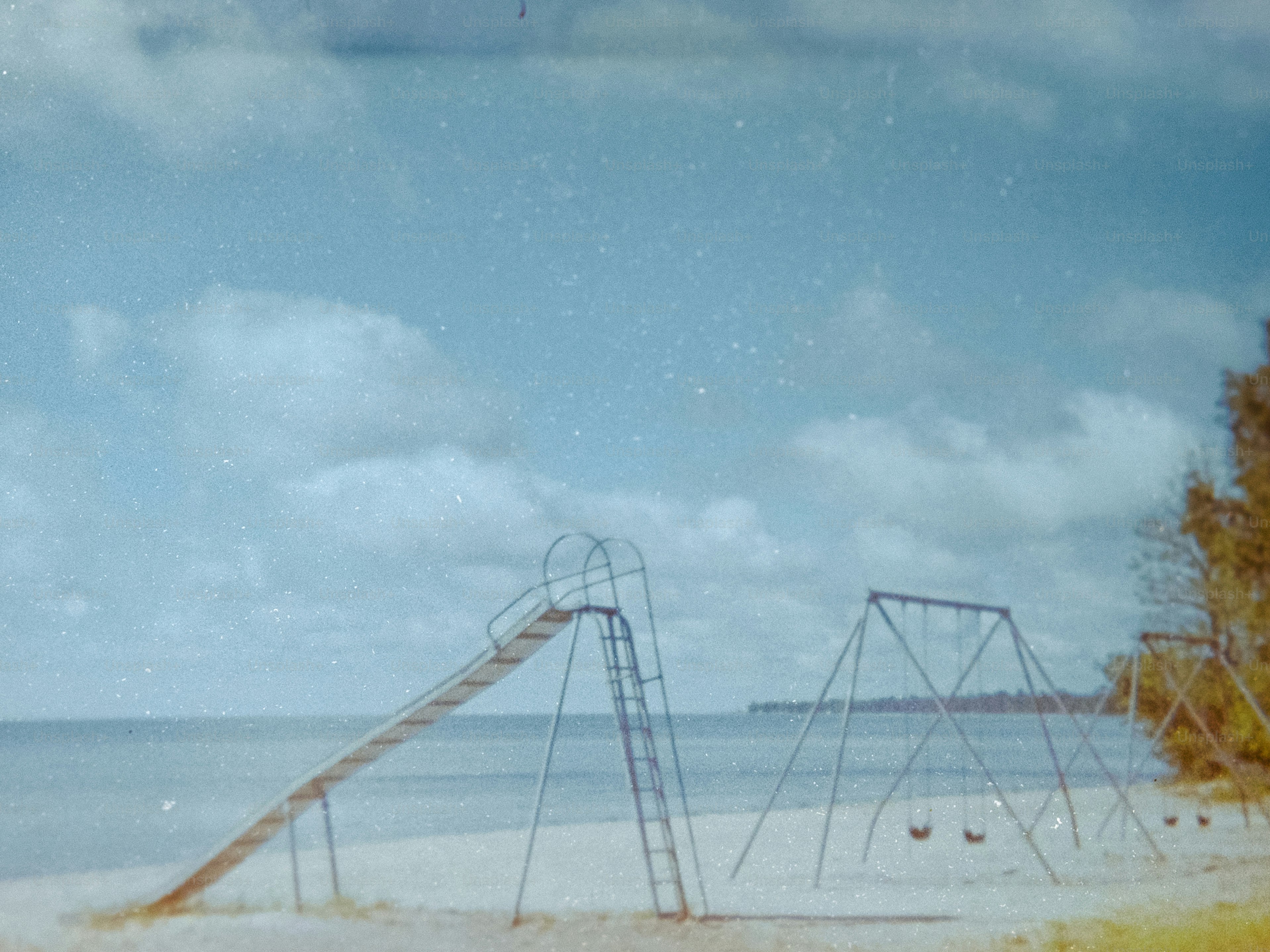Des équipements de jeux sur une plage de sable au bord de l’océan.