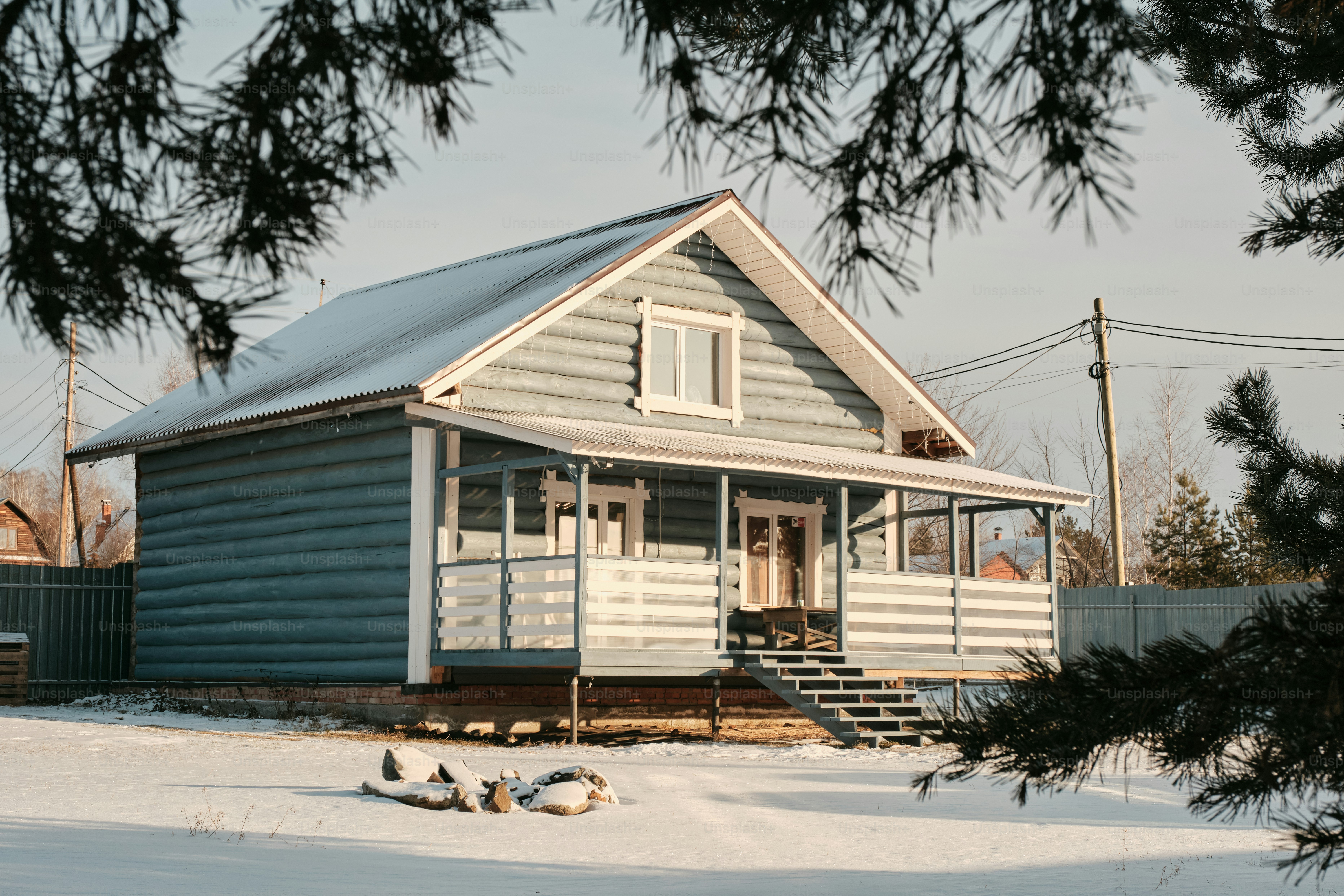 A blue wooden house in a snowy landscape.