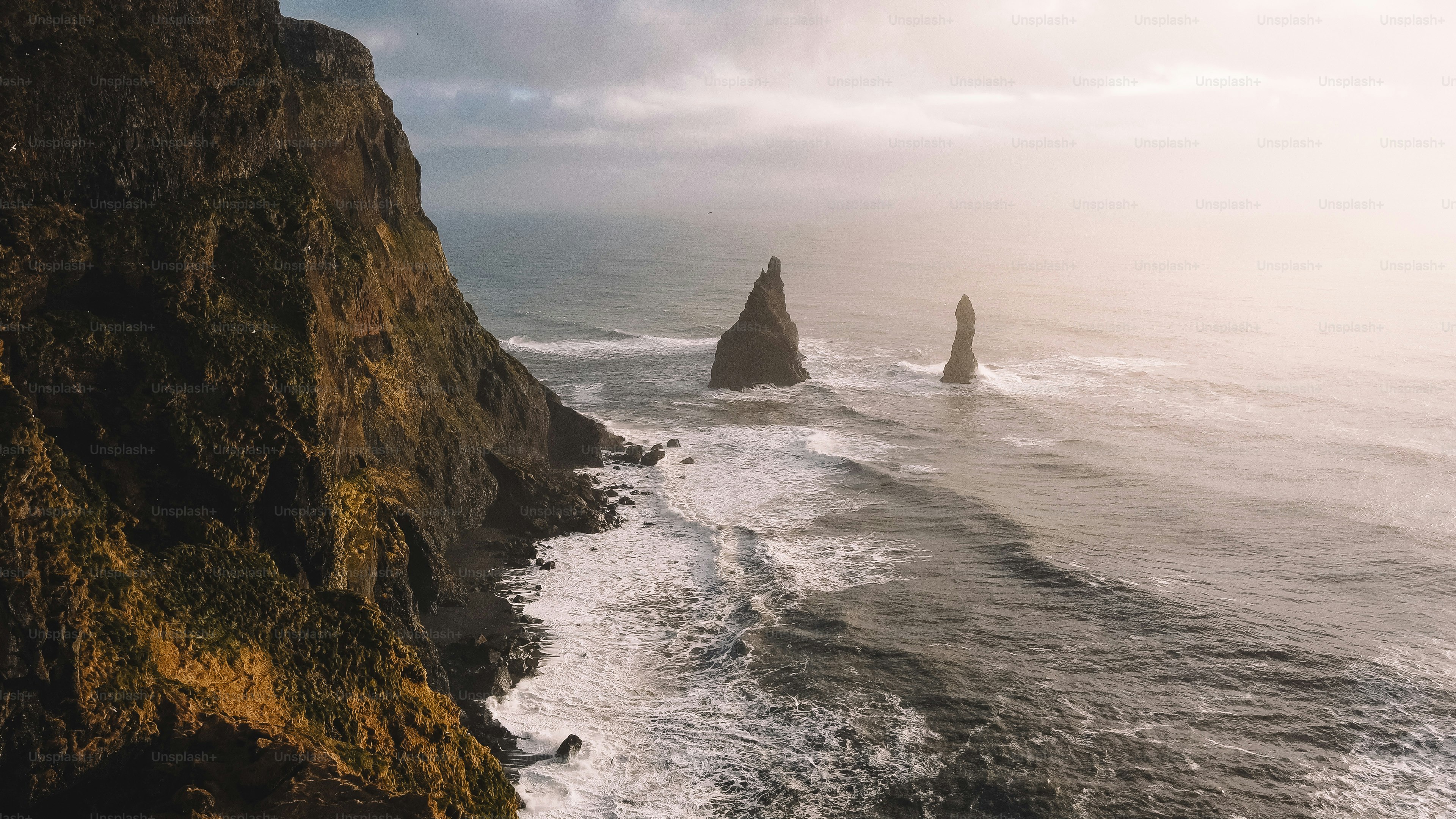 Jagged sea stacks rise from the ocean waves.