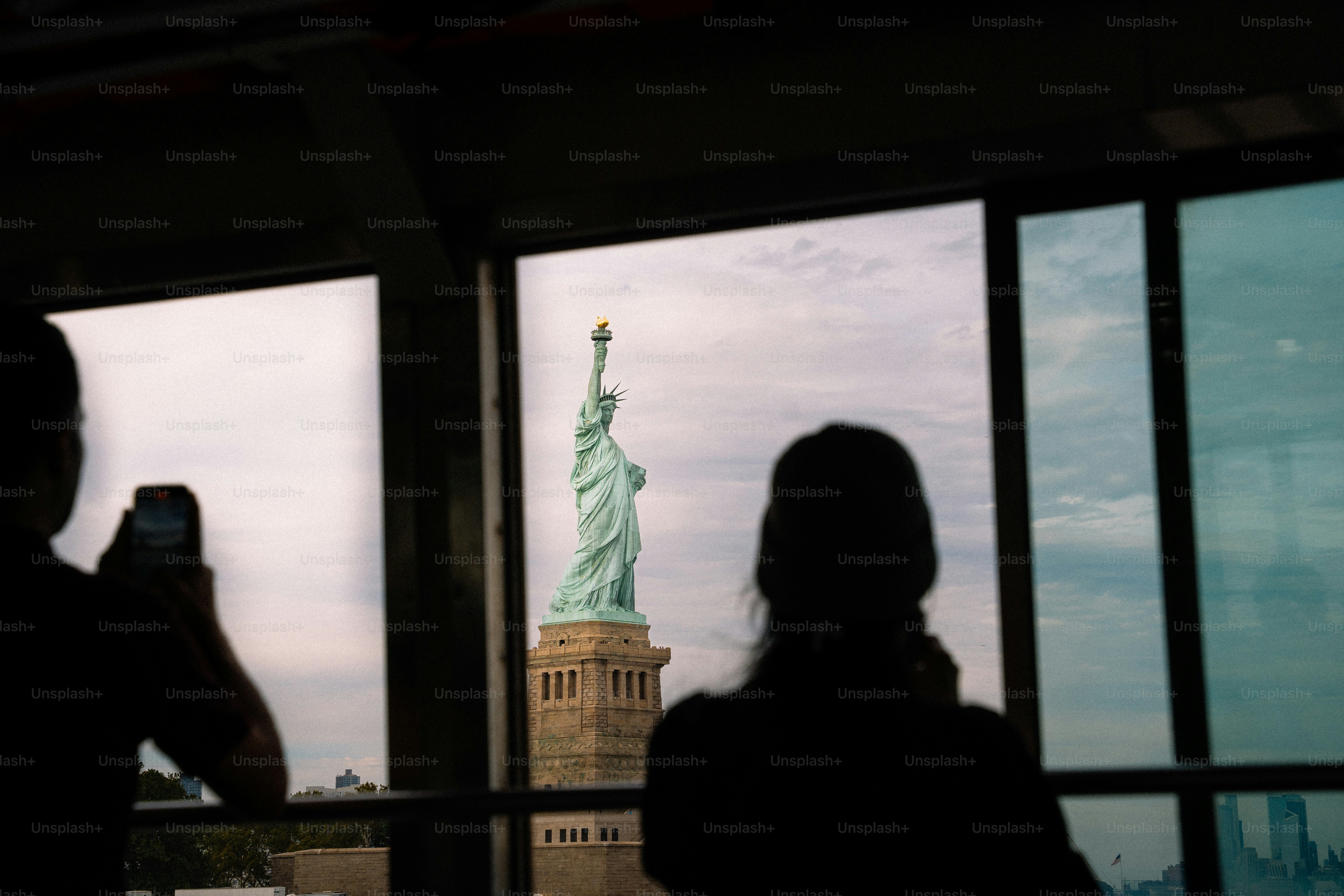 Statue of liberty viewed through window with people
