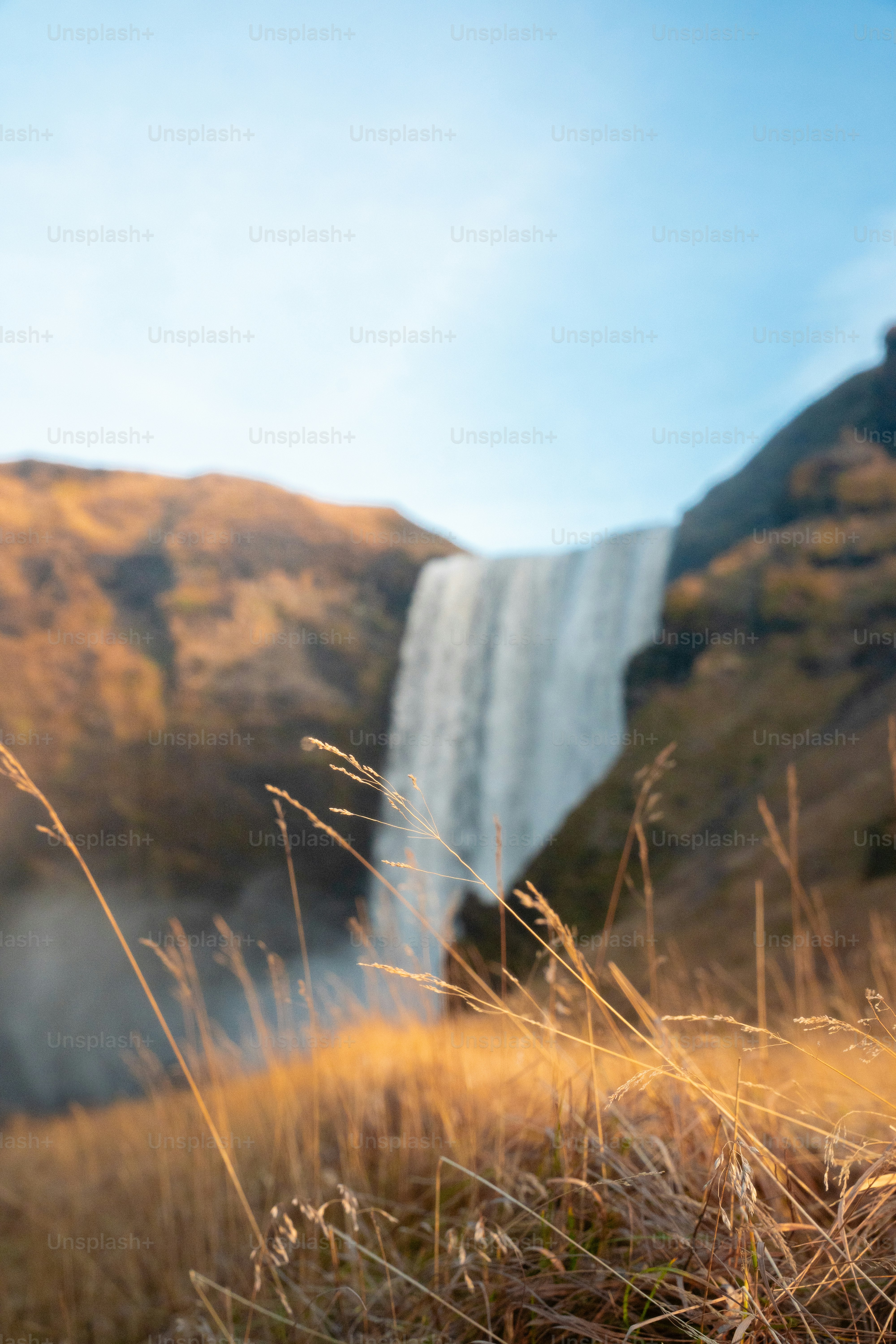Una alta cascada cae por la pared rocosa del acantilado