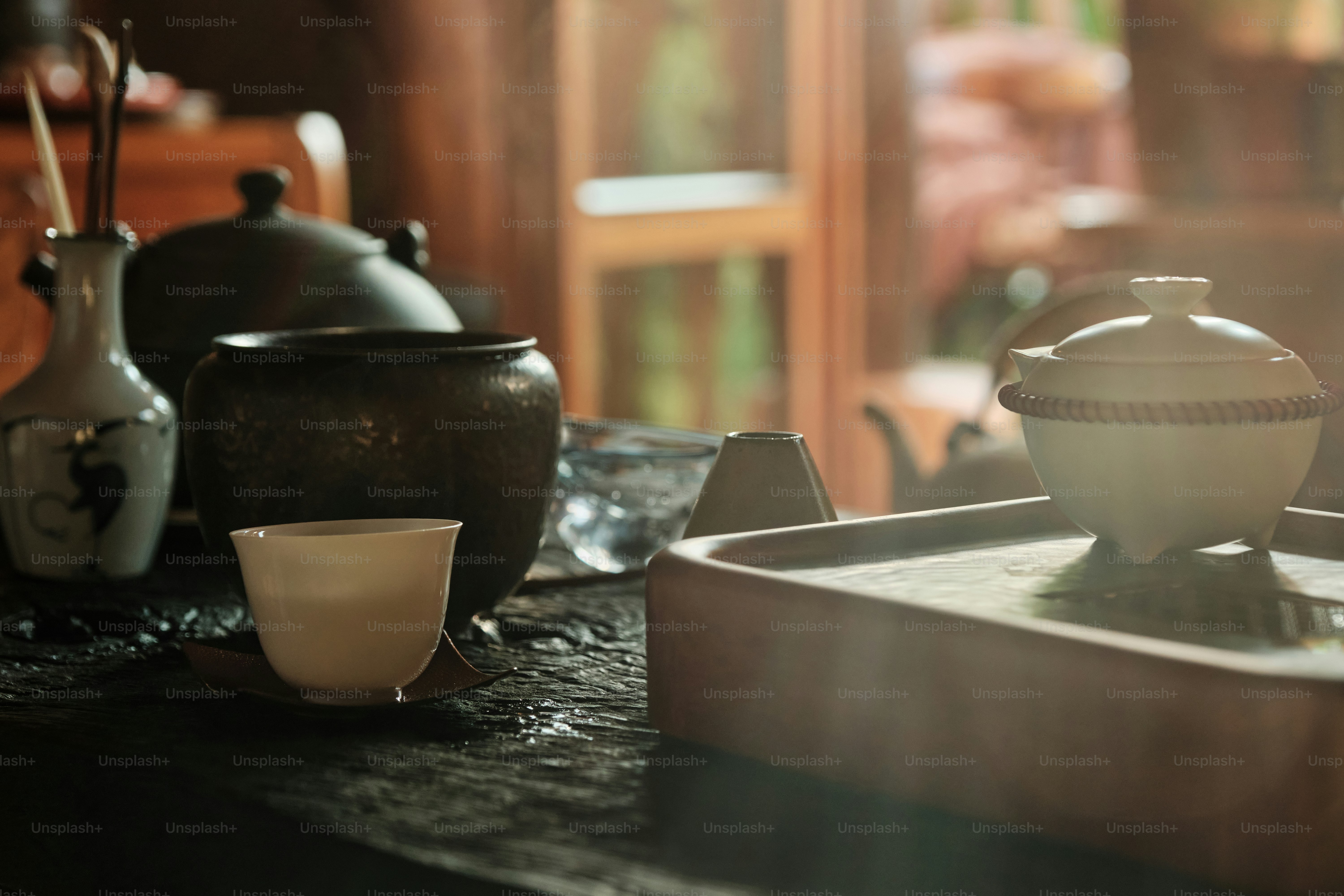 Juego de té tradicional con tazas y cafeteras sobre la mesa
