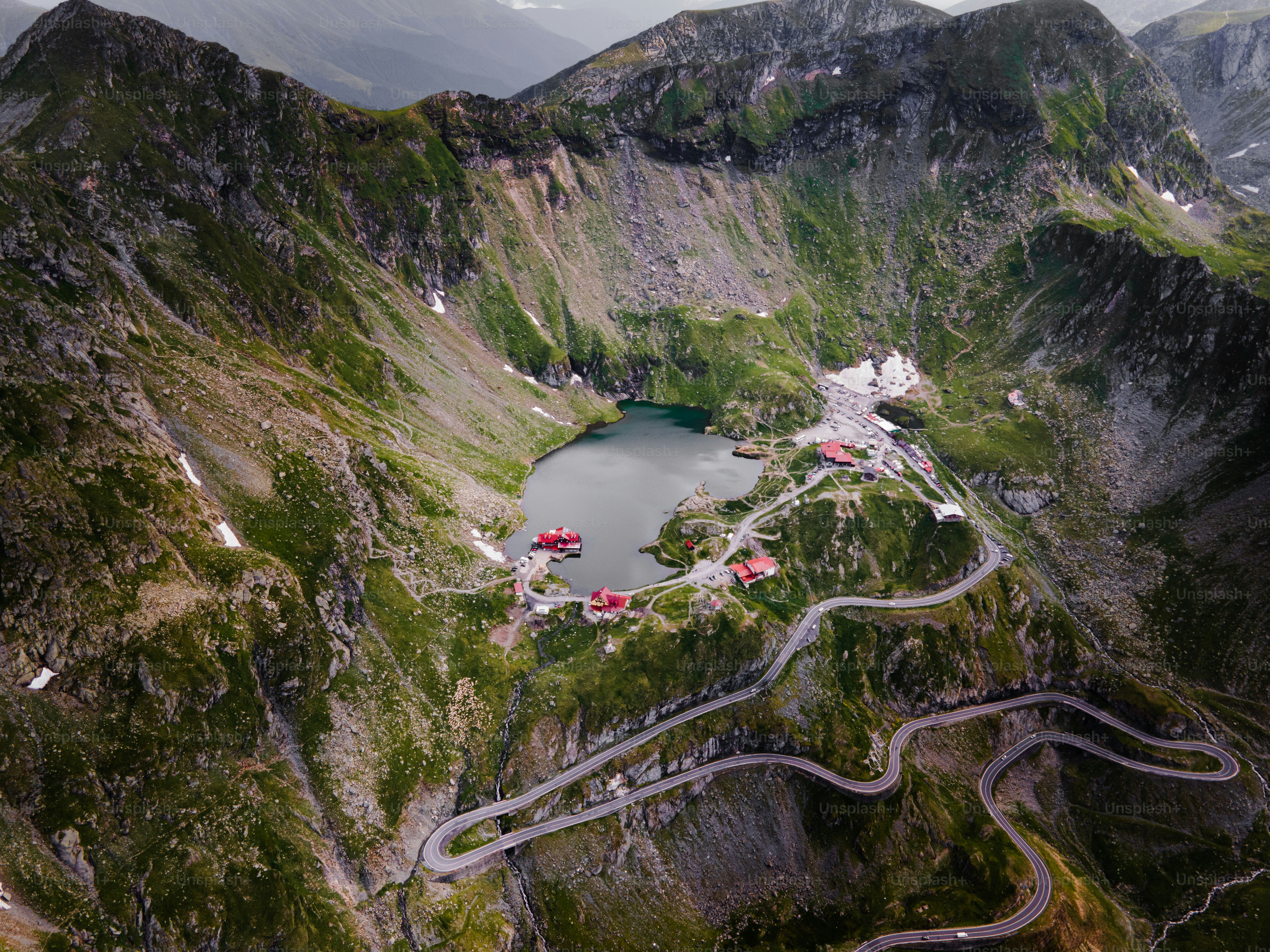 Winding mountain road leads to a serene alpine lake.