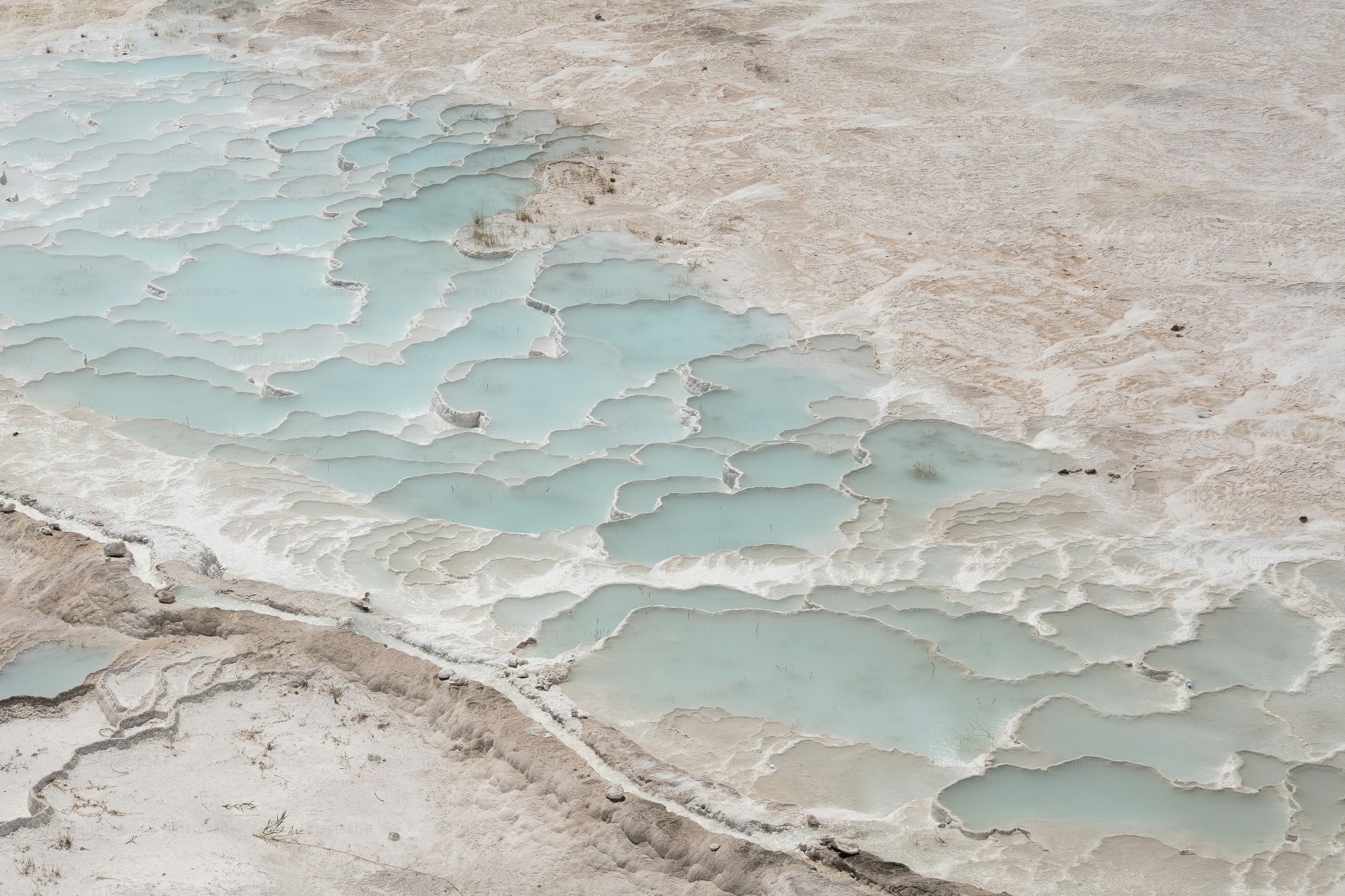Terrace pools with turquoise water and white mineral deposits.