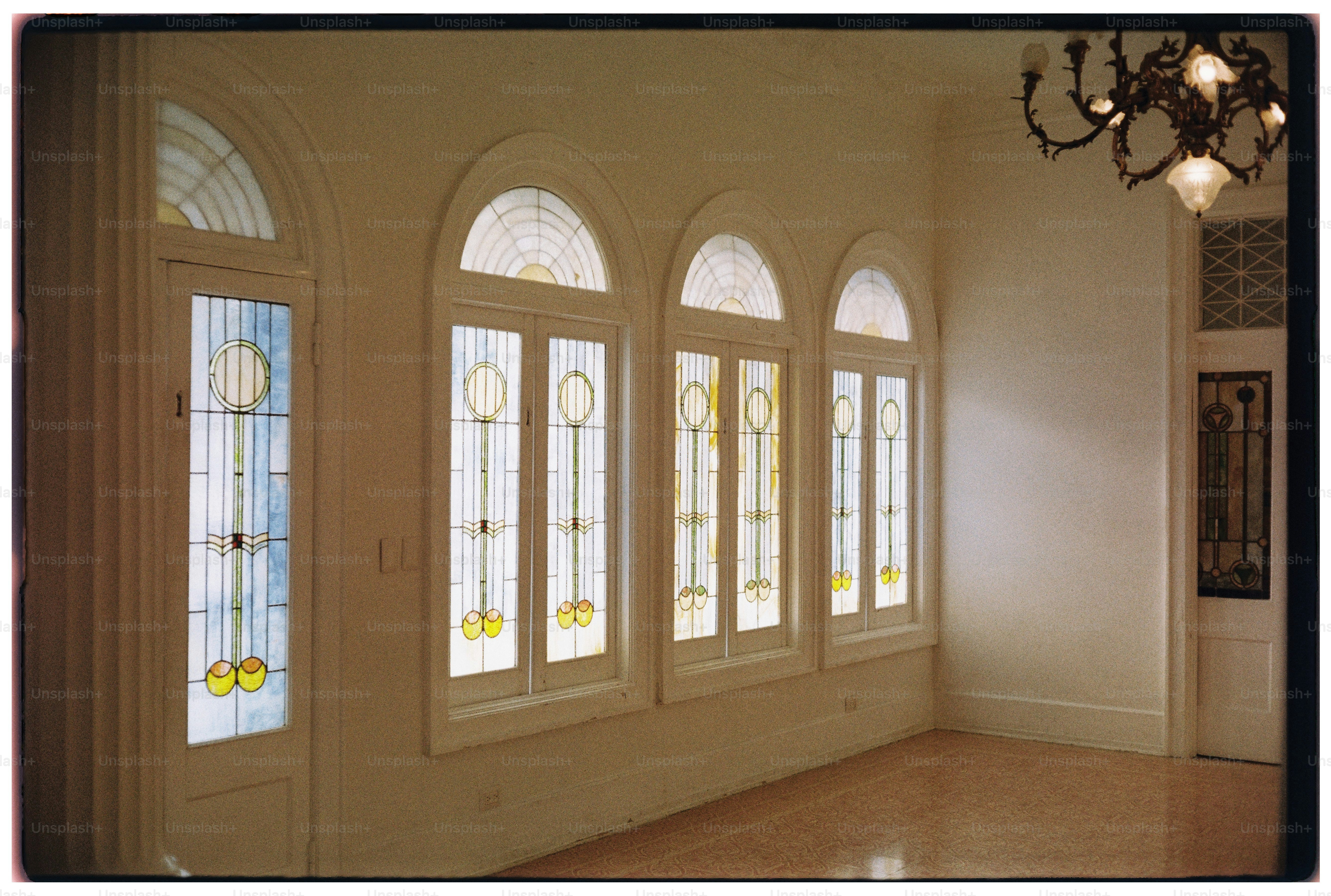 Arched stained glass windows in a bright room.