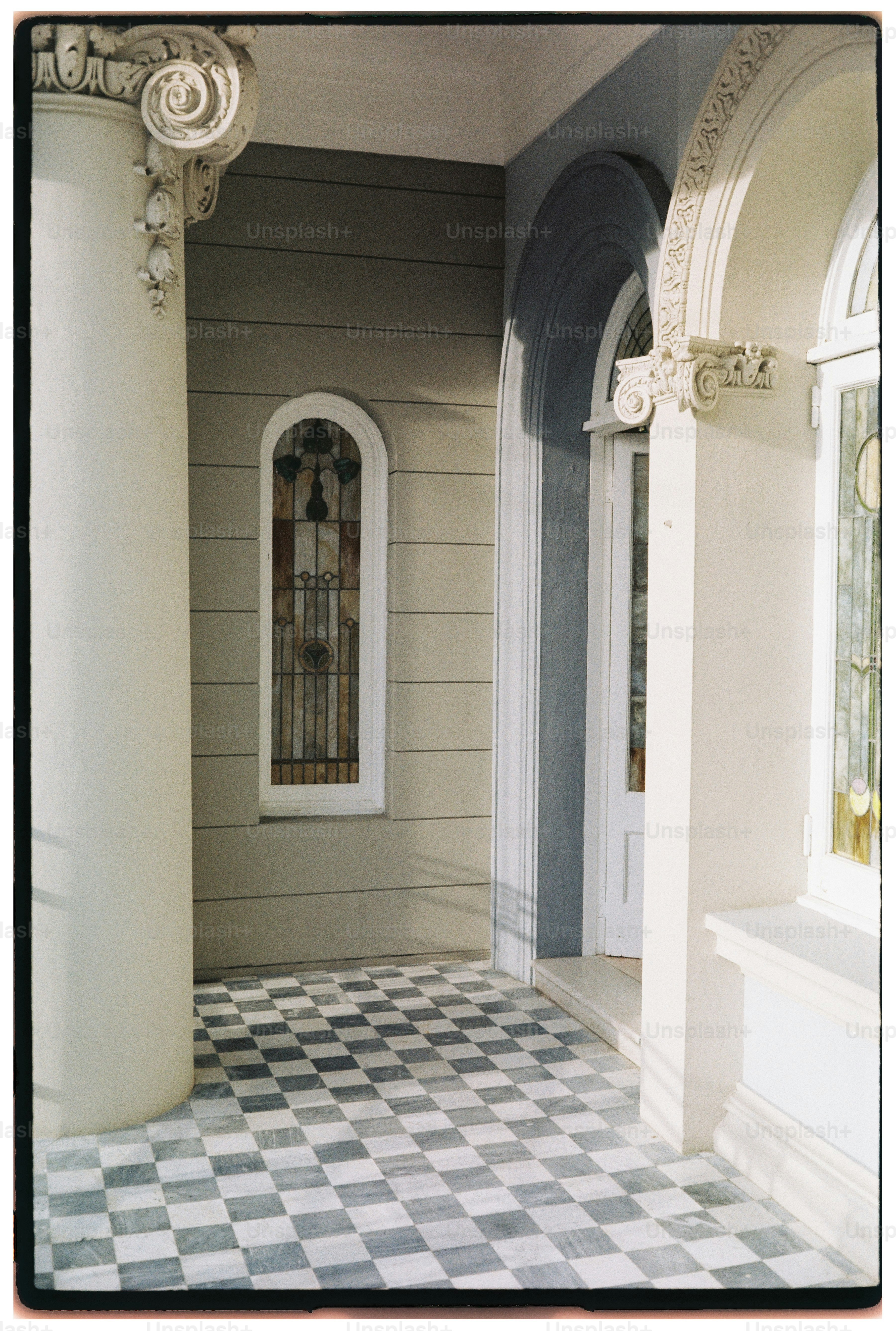 Checkerboard floor leads to arched doorway and window