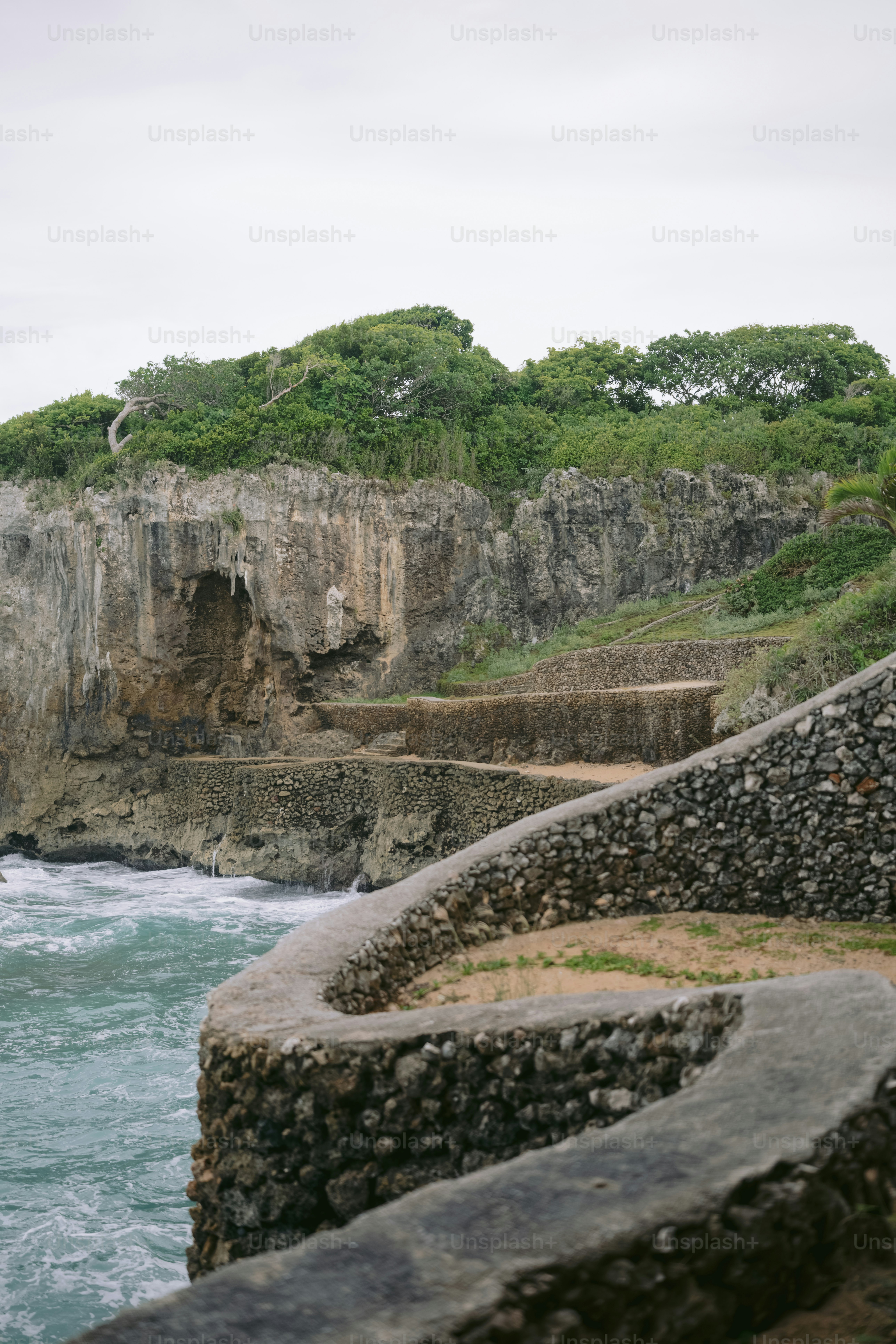 Stone steps lead down to the ocean along a cliff.