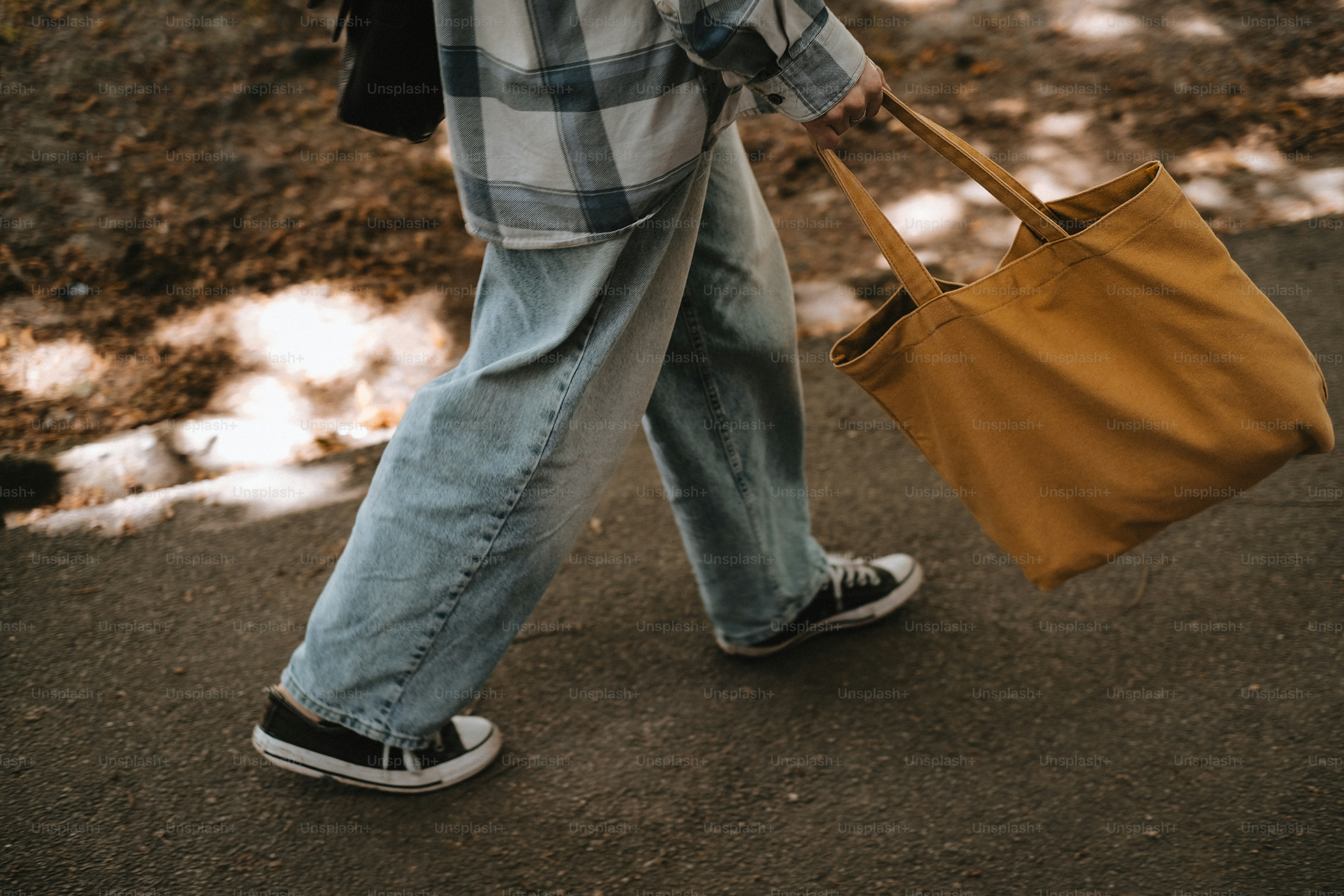 黄色いトートバッグを持った人が歩いている