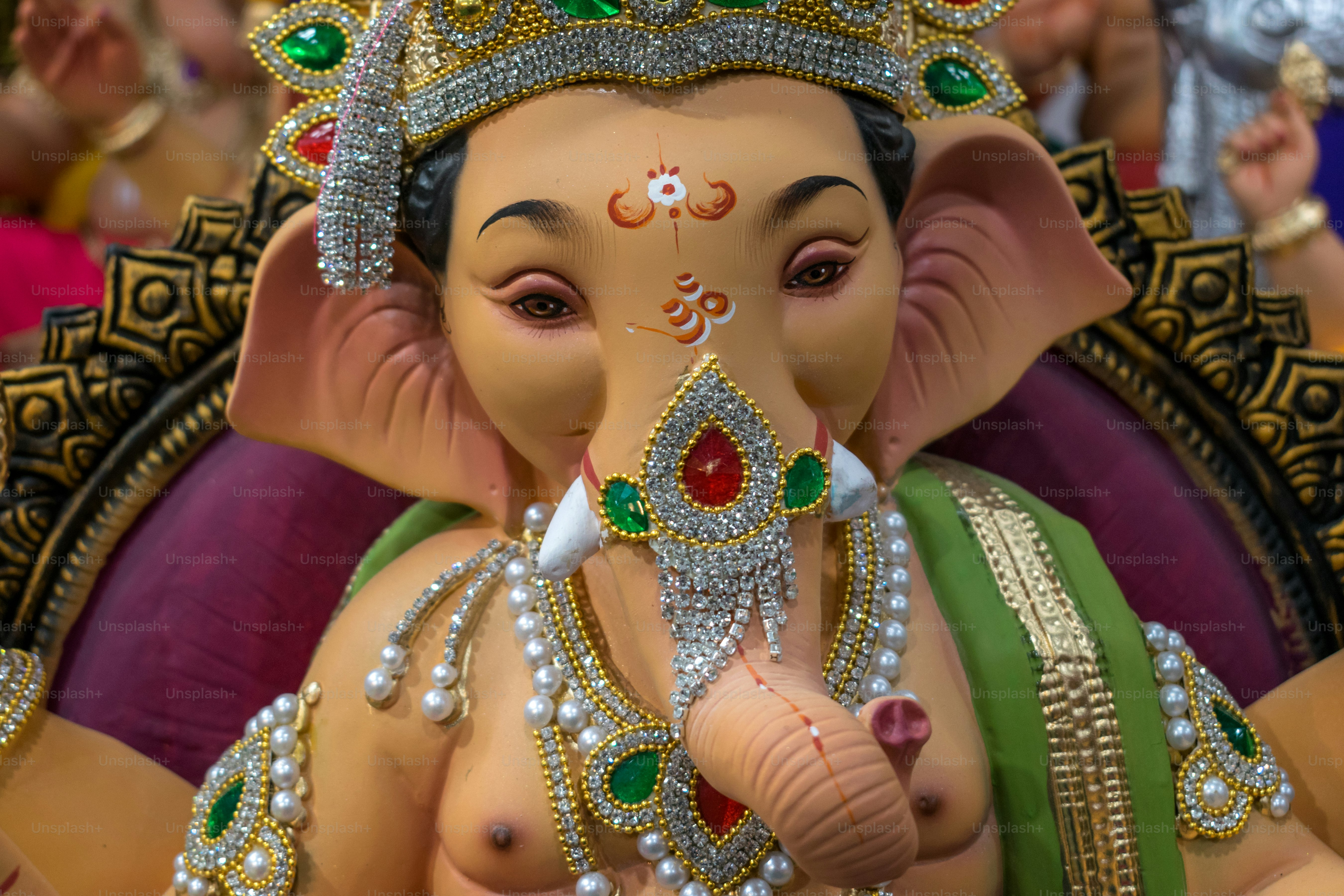 Ornate statue of lord ganesha with jeweled headdress.