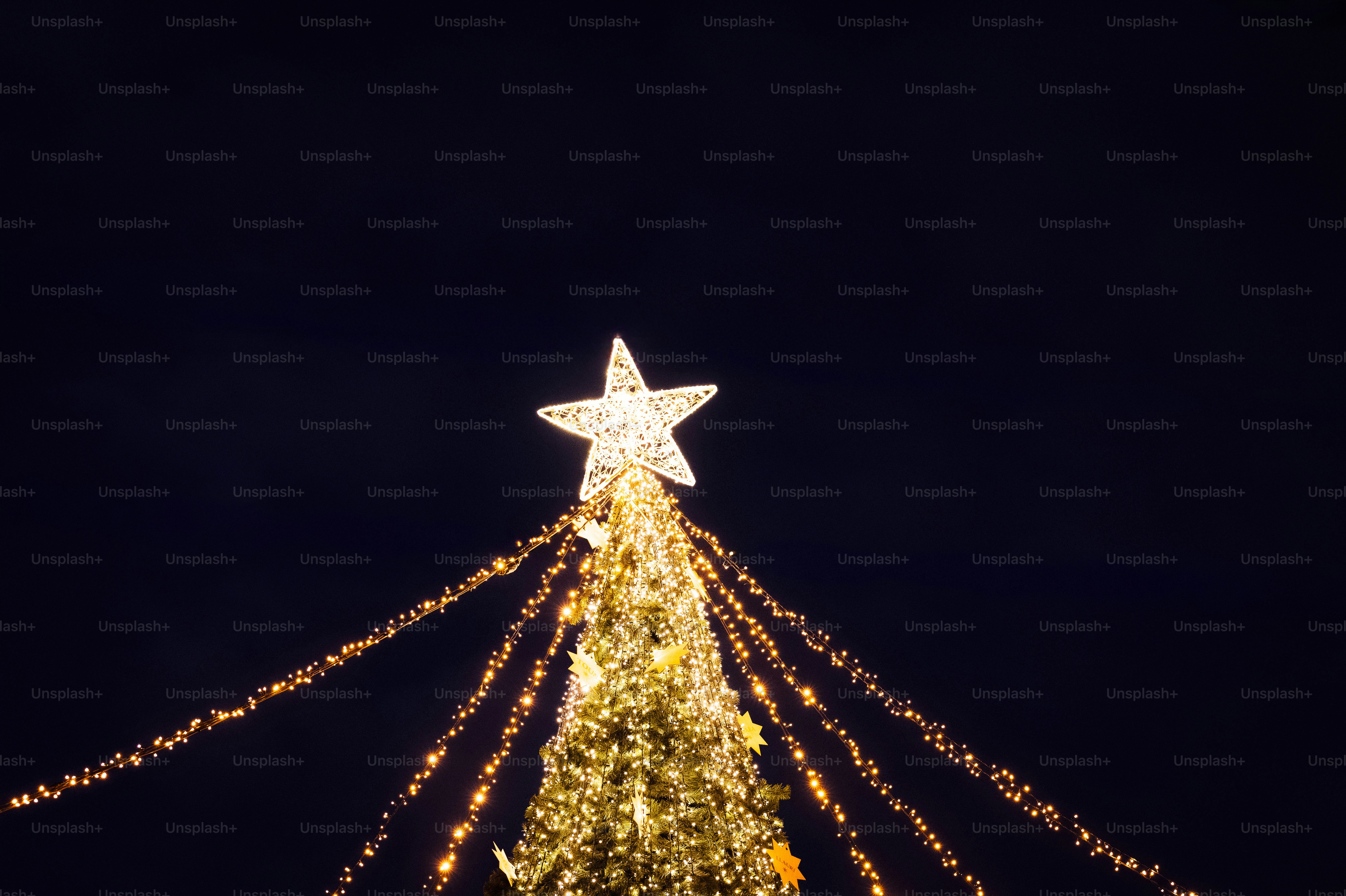 Un árbol de Navidad decorado con una estrella por la noche