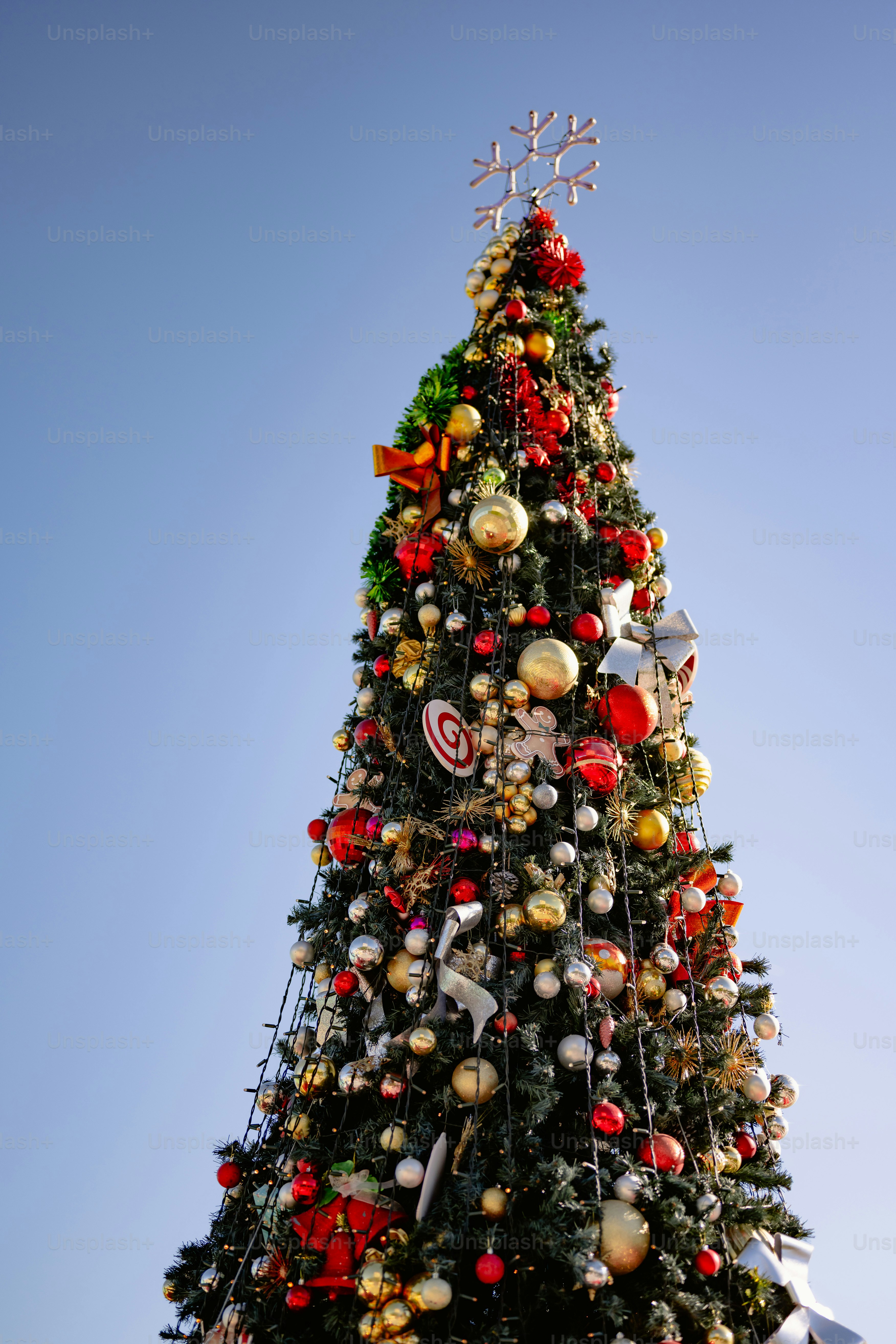 Un árbol de Navidad decorado contra un cielo azul claro.