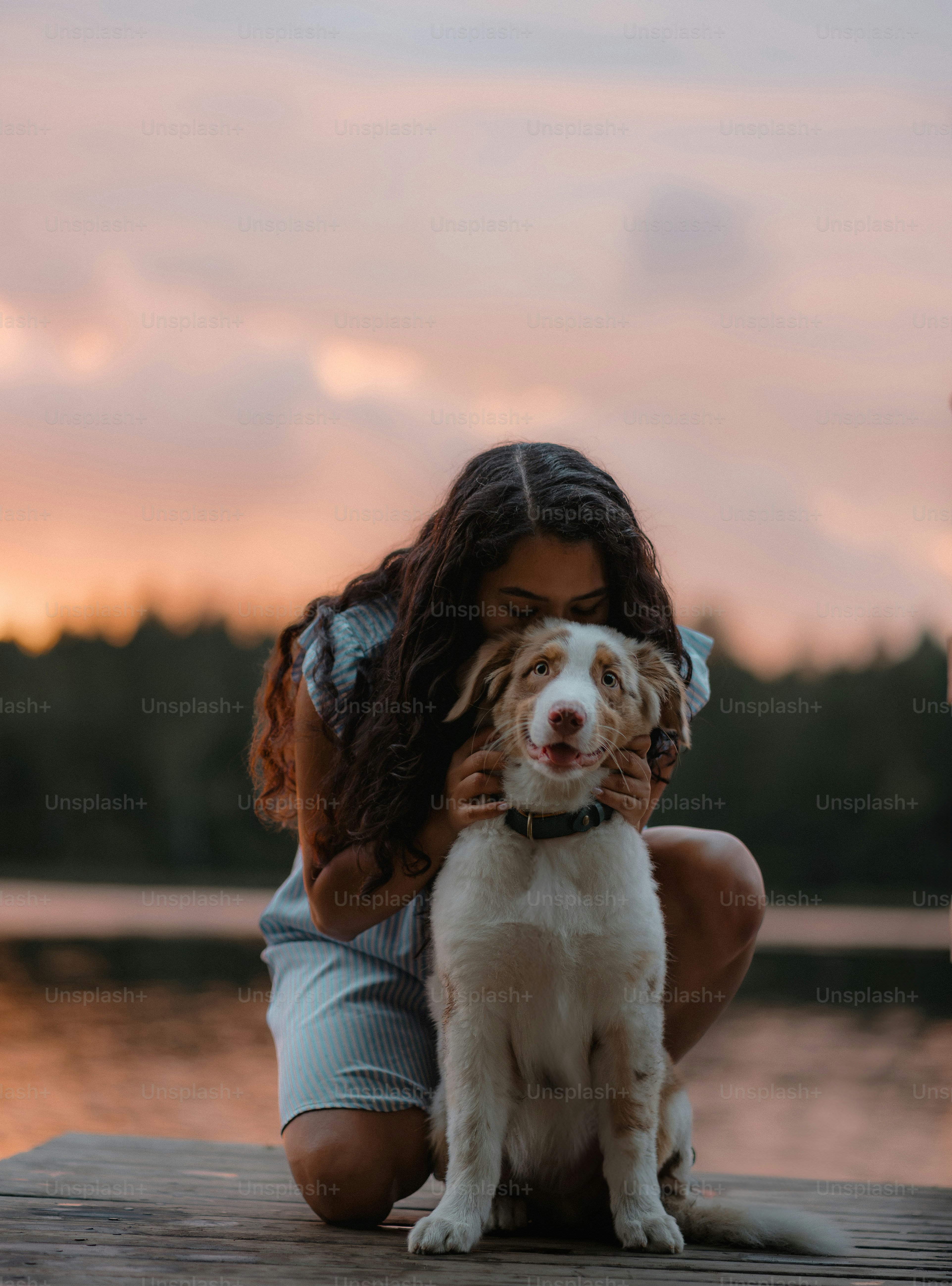 Girl hugging her dog at sunset