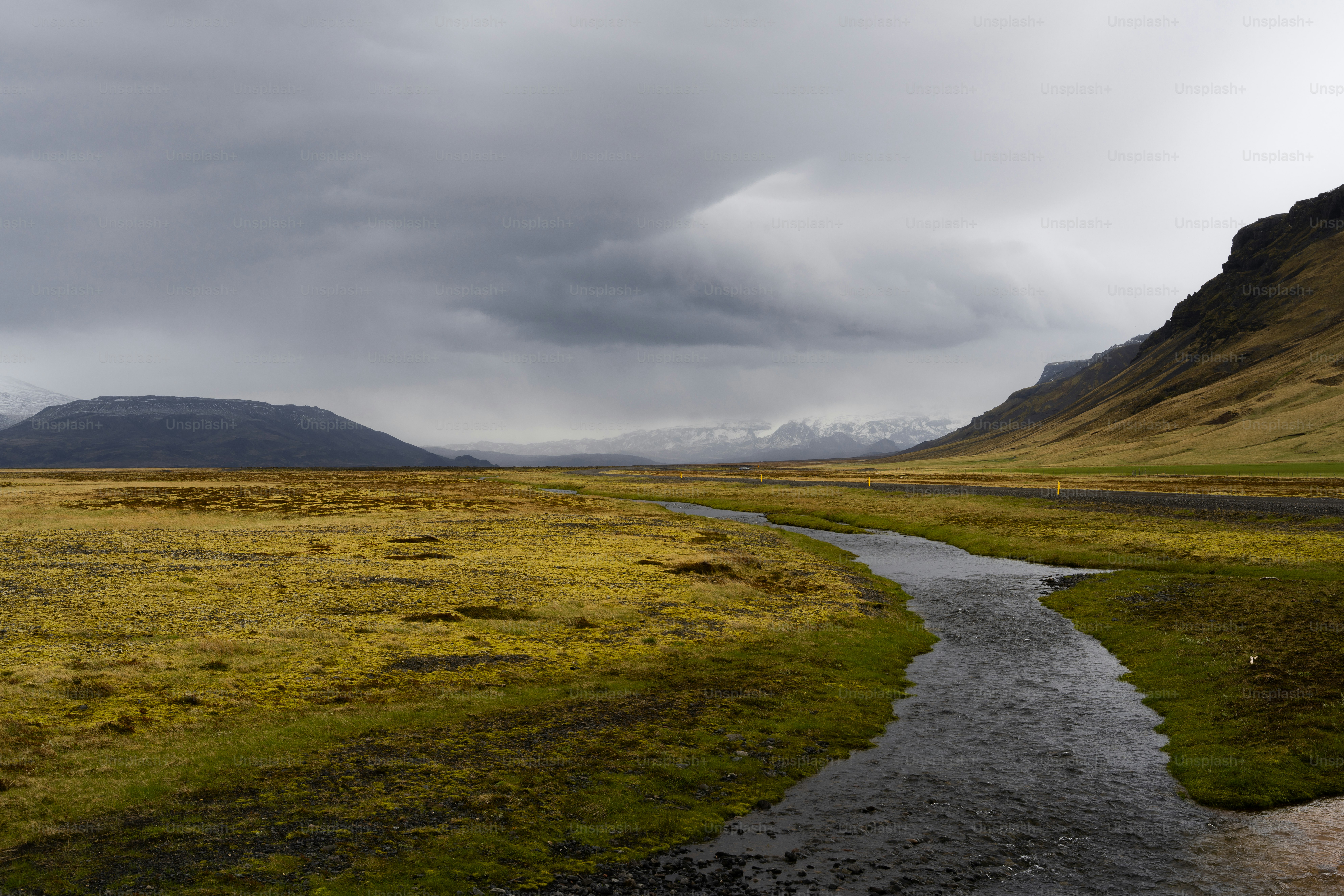 A winding river flows through a vast, grassy plain.