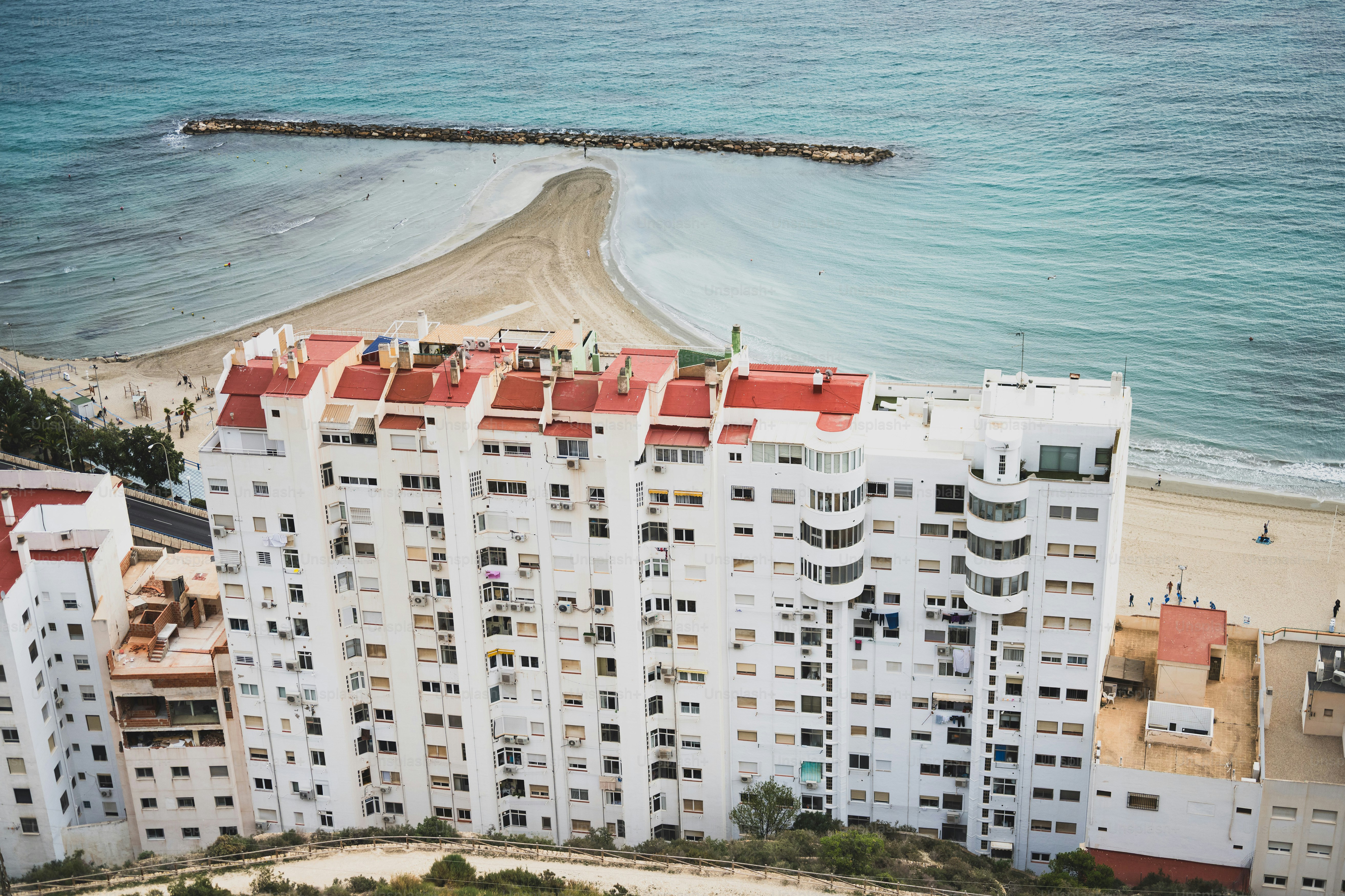 White apartment building with red roofs by the sea