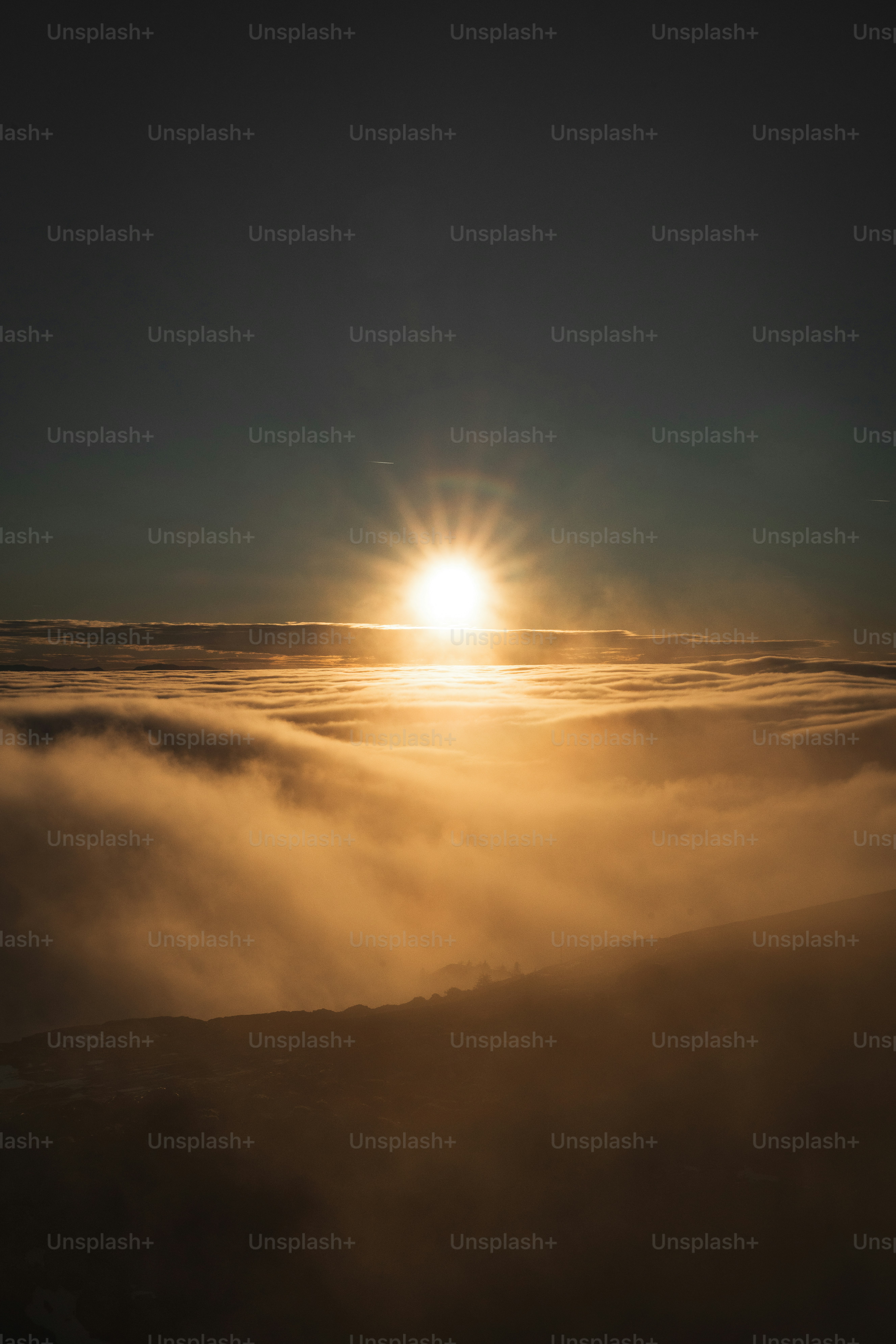 Golden sun setting over a sea of clouds