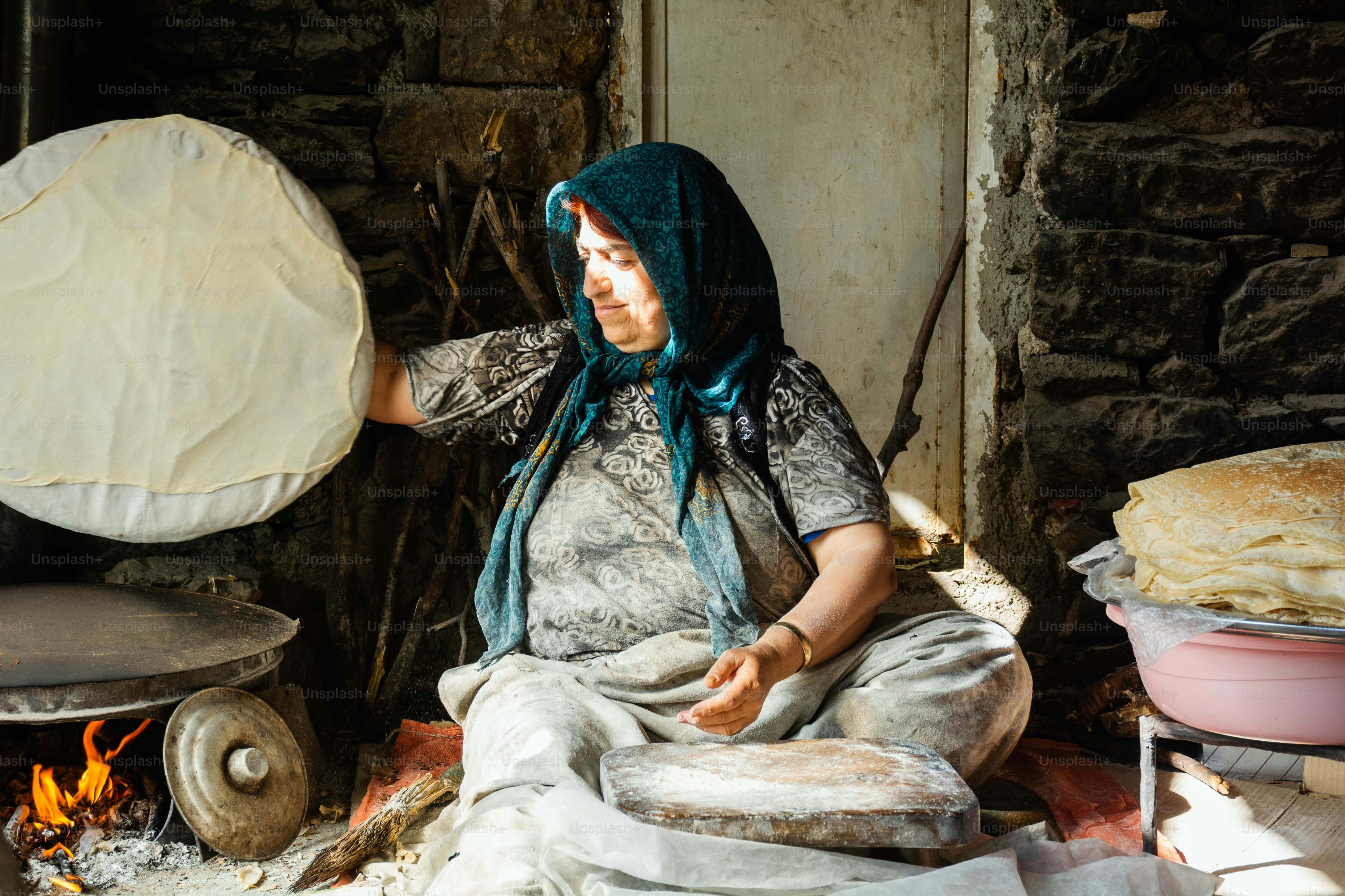 Woman making flatbread in a traditional stone oven.