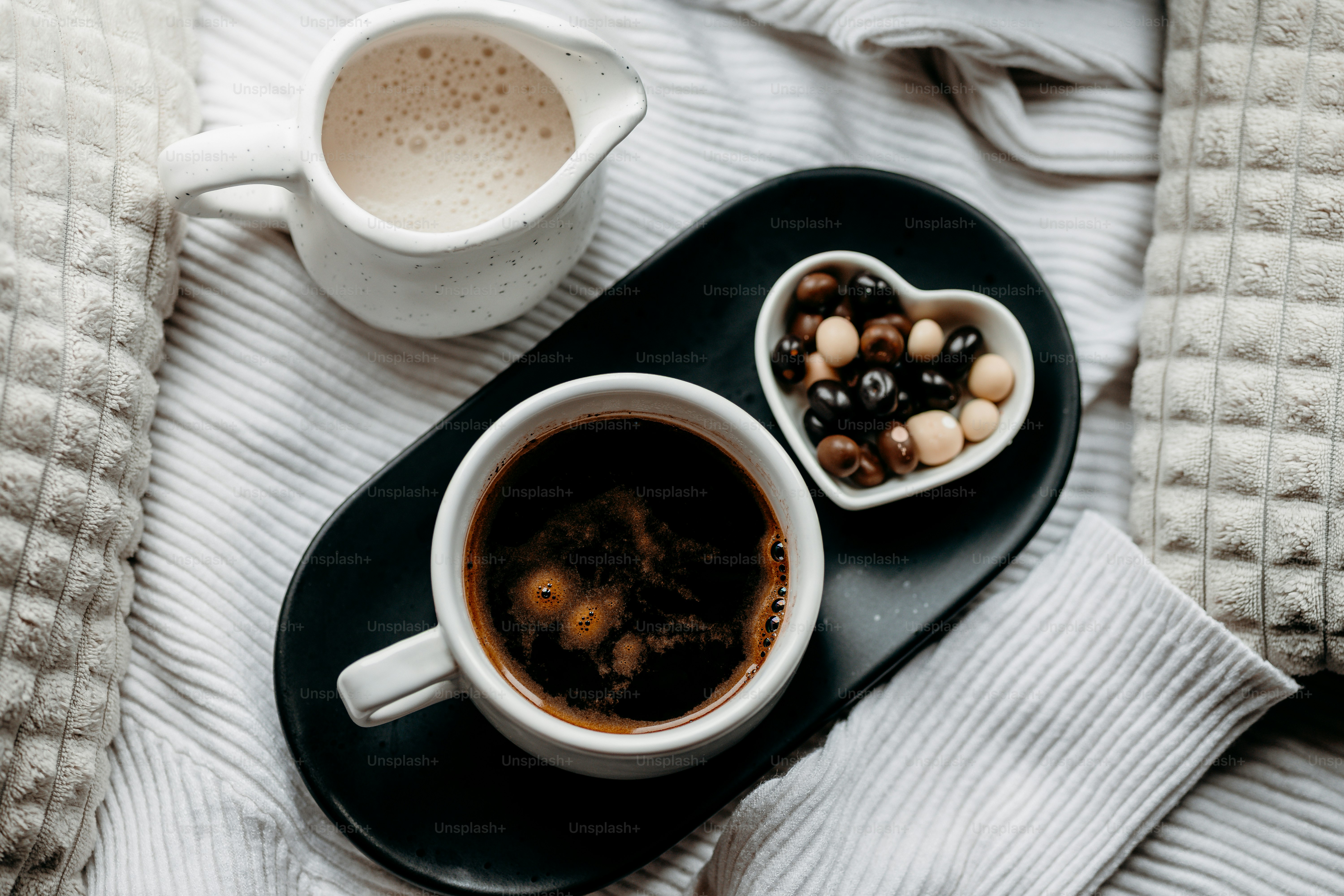 Cup of coffee with cream and chocolate candies
