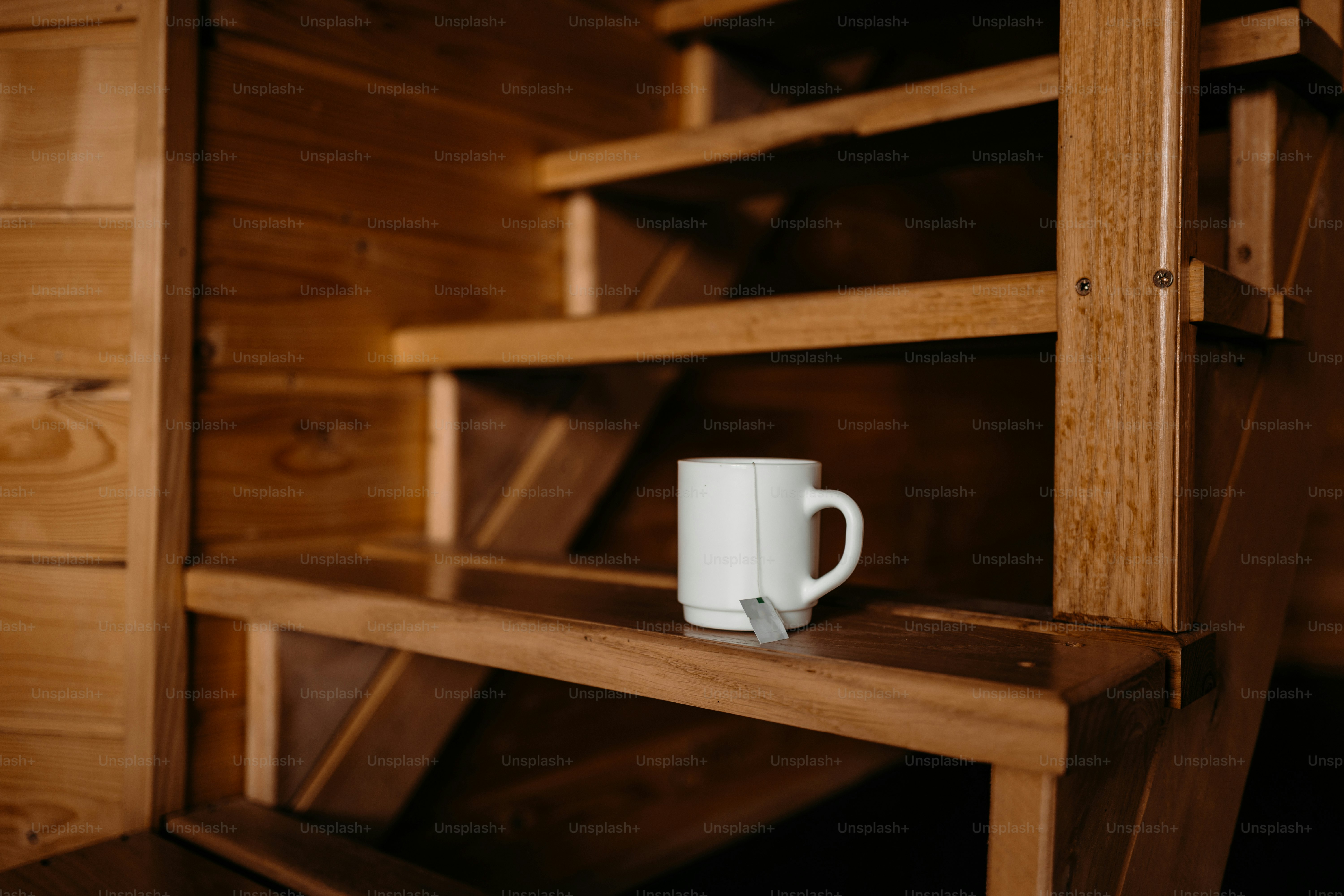 White mug with tea bag on wooden stairs