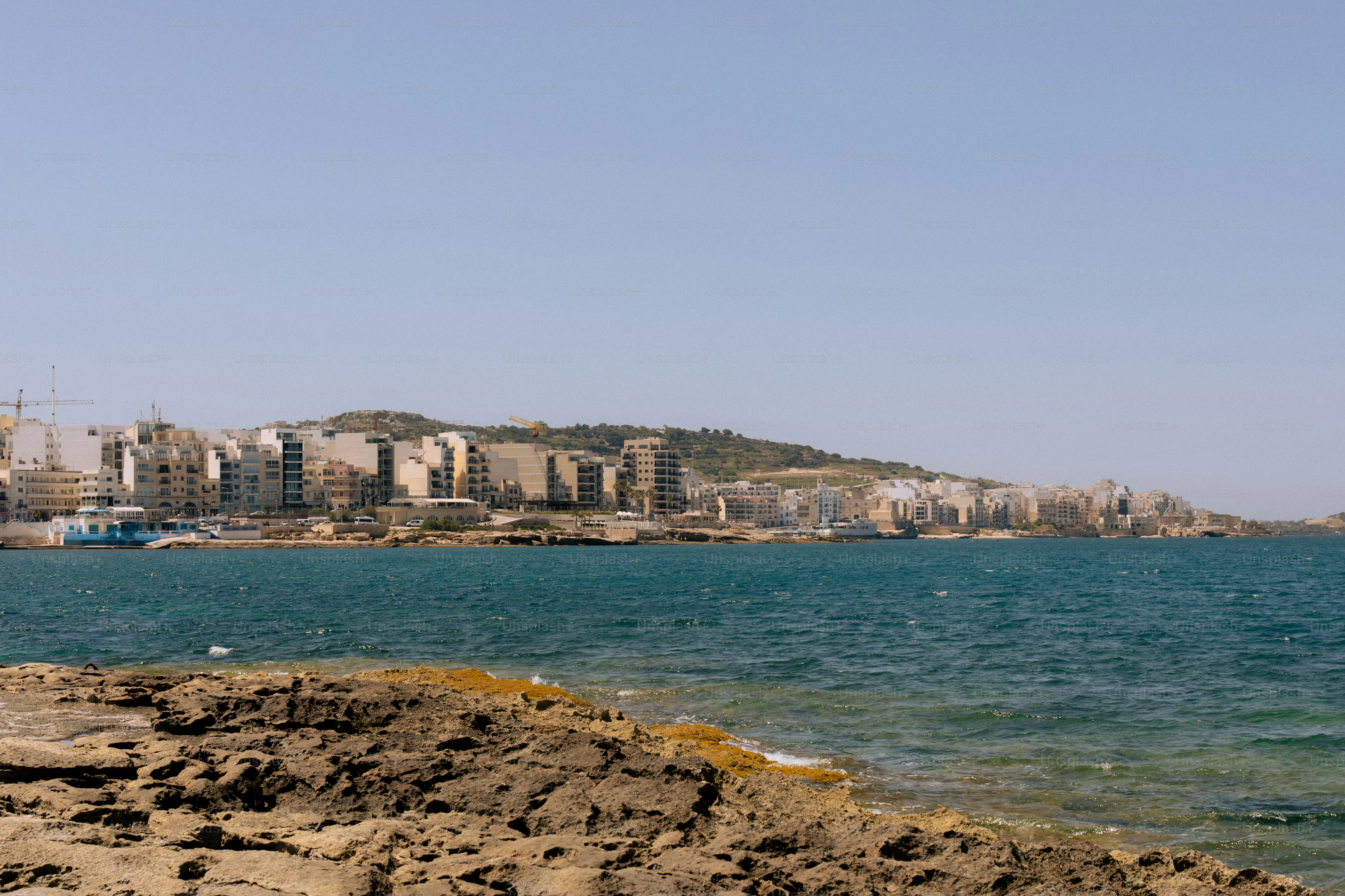 Coastal city skyline with buildings along the water.